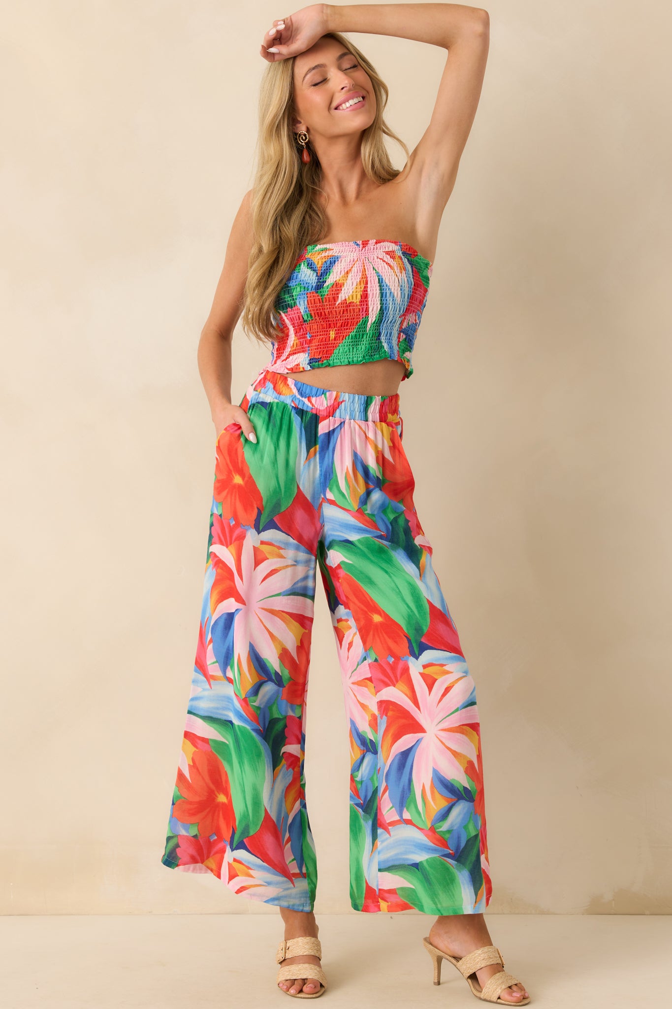 Full front-facing view of the pants showcasing the pink multicolor tropical floral print, wide legs, and relaxed drape.