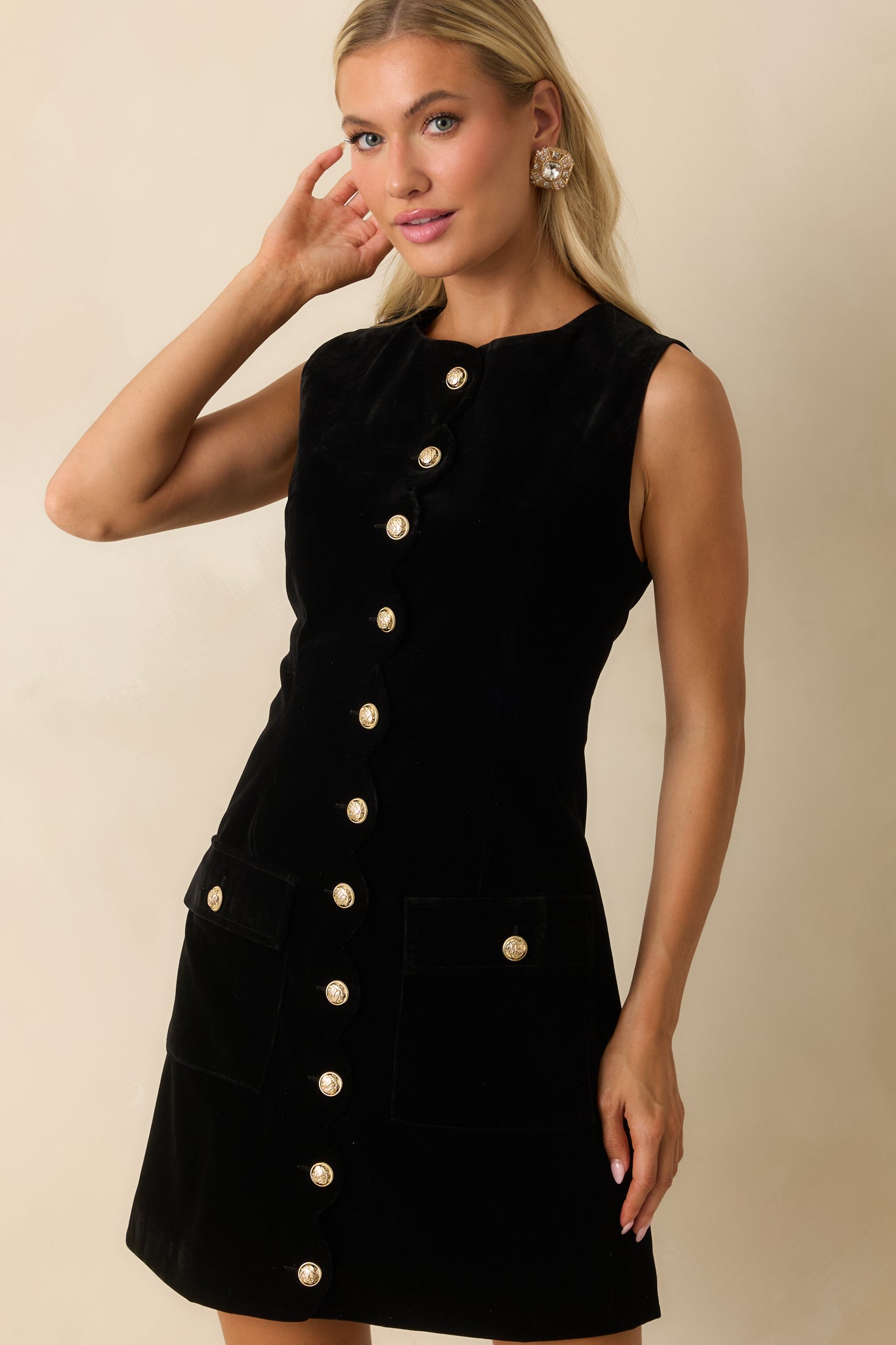 Cropped view focusing on the front flap pockets and sculpted fit of the black velvet dress.