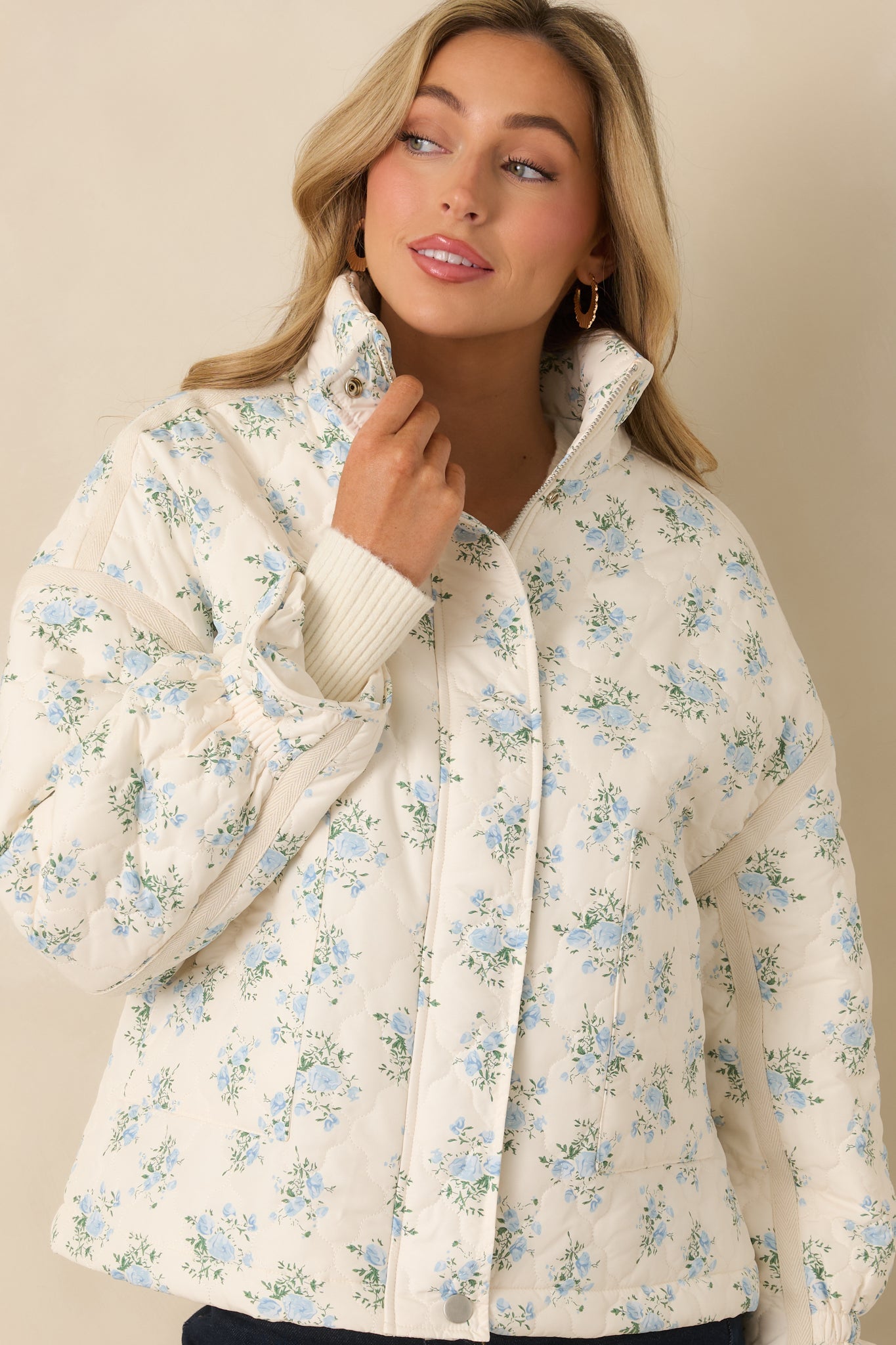 Front-focused crop showing the functional pockets, floral quilting, and smooth fabric texture.