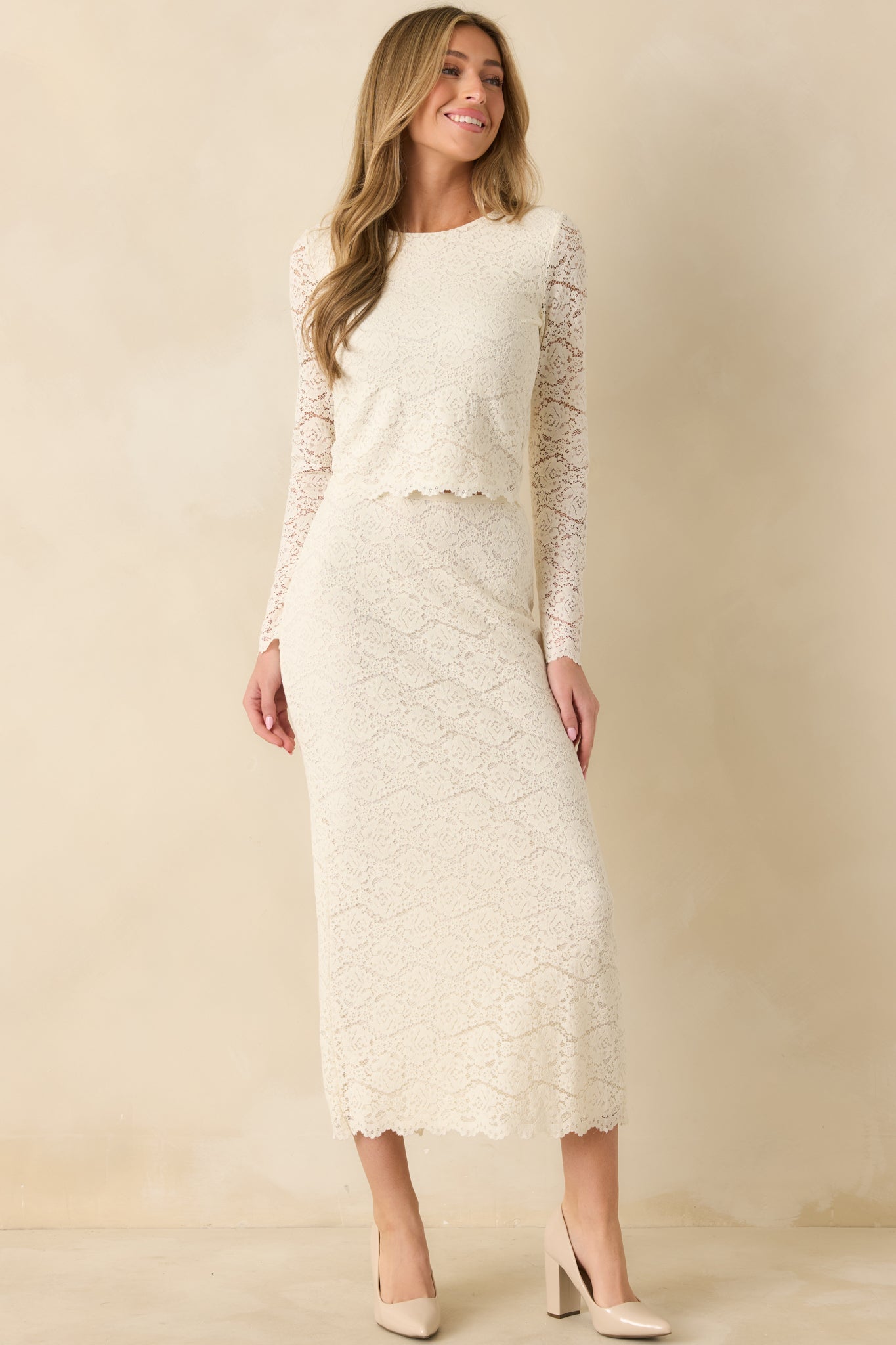 Front view of ivory lace midi skirt showing floral lace overlay, straight silhouette, and elastic waistband.