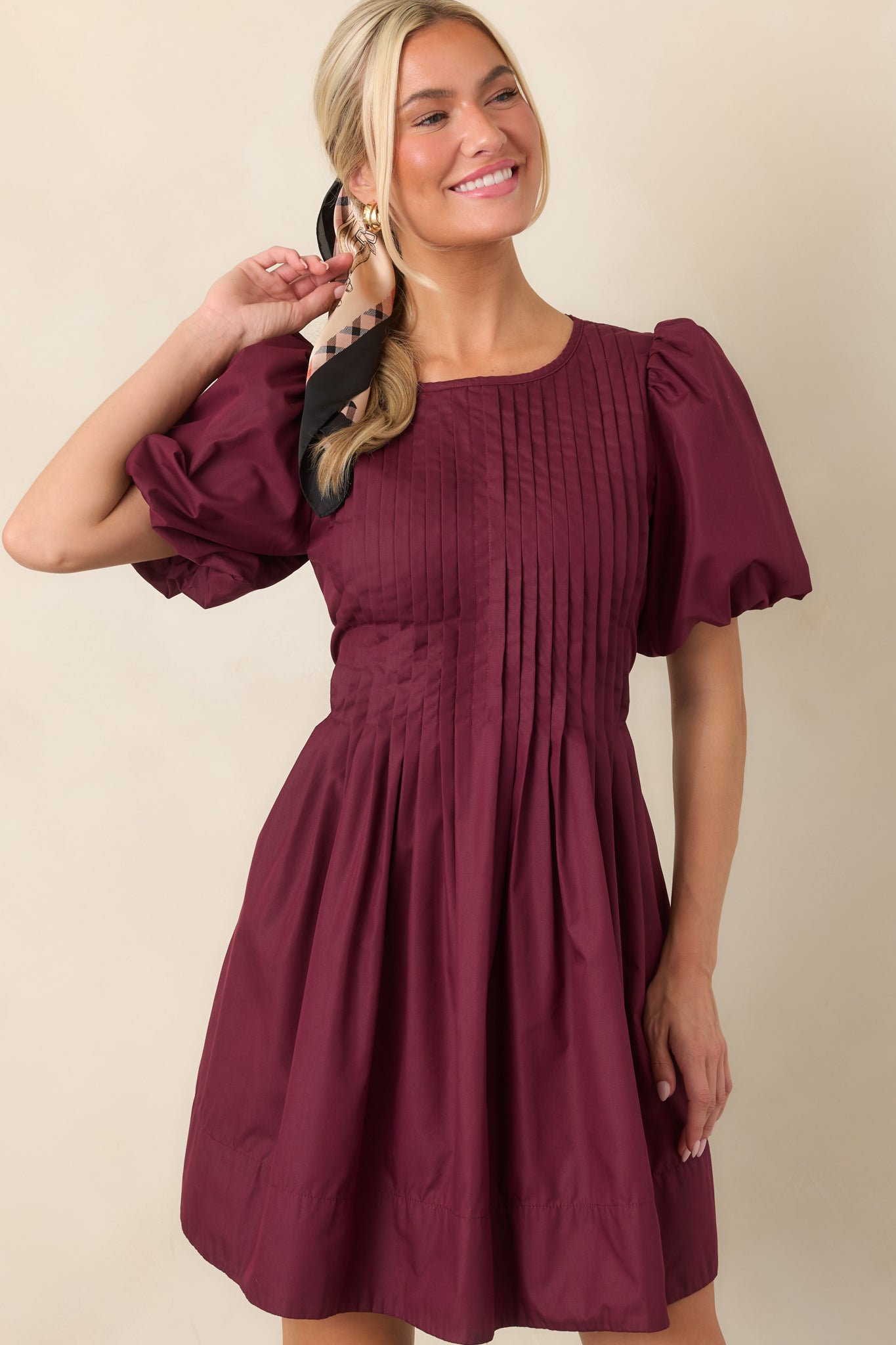 Close view of the mini dress highlighting the intricate pintucking across the front bodice and the softly gathered skirt.