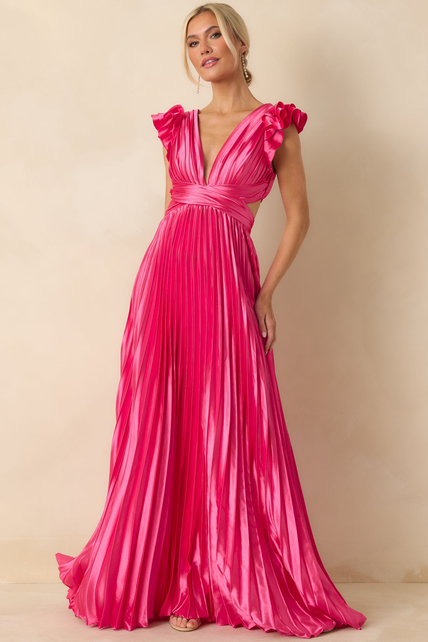 Front-facing shot emphasizing wrap-style detailing, deep V-neckline, and full pleated skirt.
