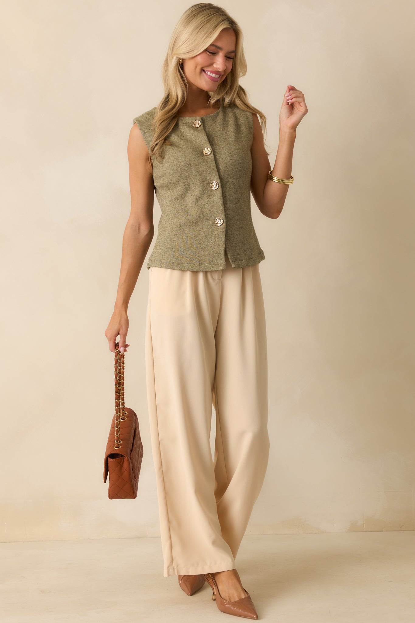 Front view of the sweater vest in light olive green, highlighting its straight hemline and sleeveless design.