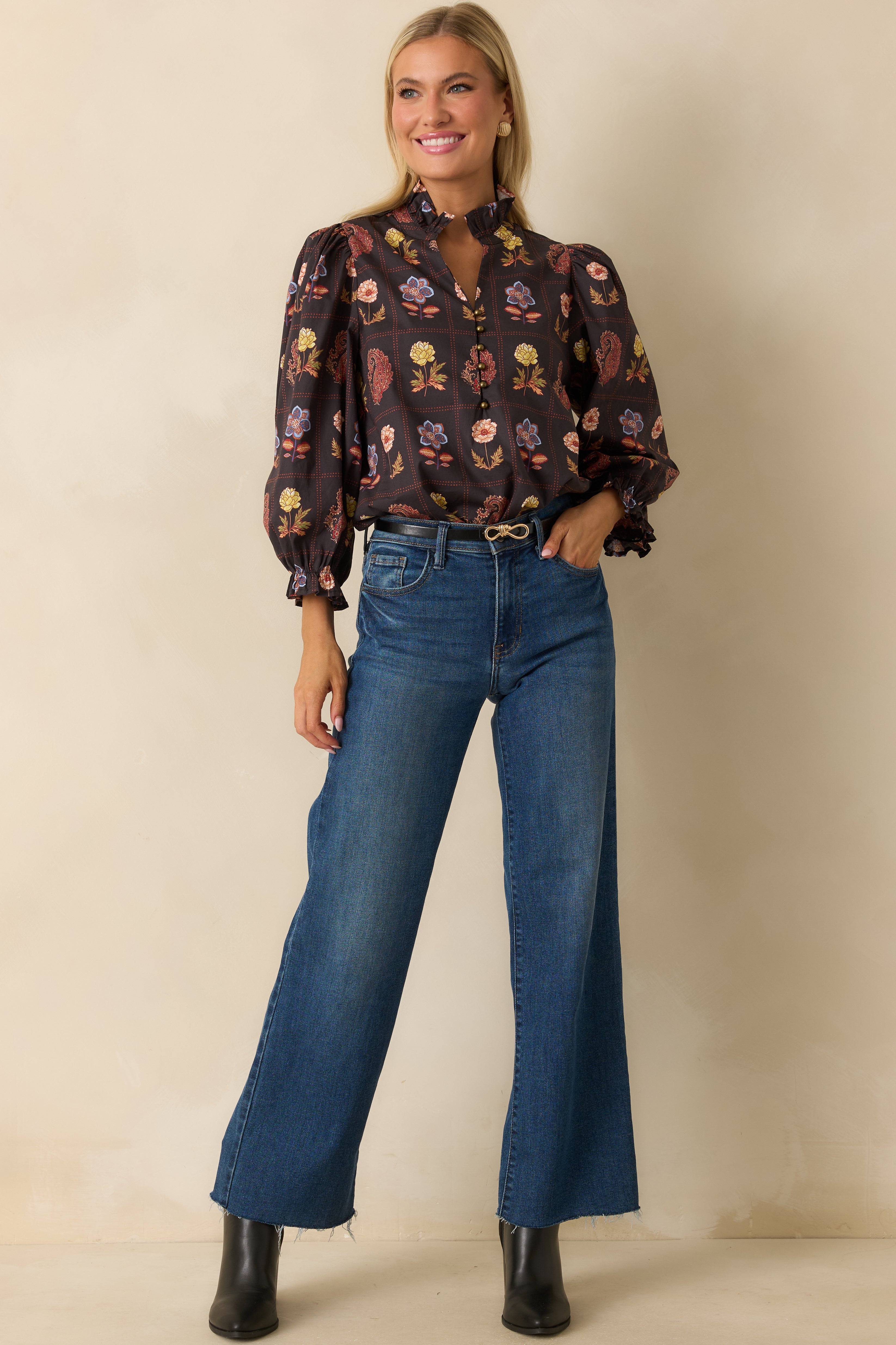 Front view of black floral blouse with puffed sleeves and flowing silhouette.