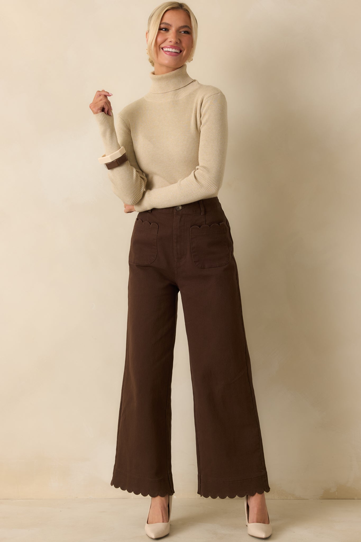 Front view of brown wide-leg pants highlighting belt loops, flowing legs, and scalloped hemline.