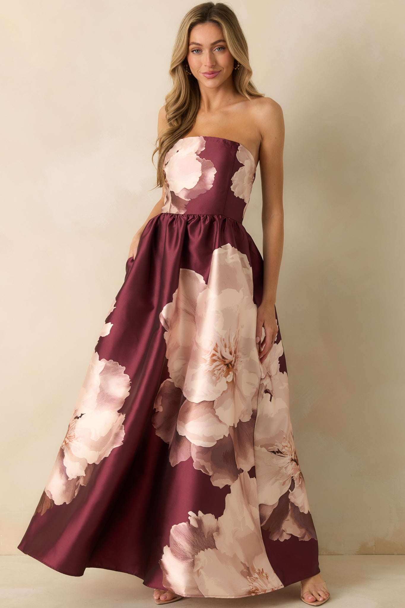 Front view of the burgundy floral satin maxi dress featuring a strapless neckline and full A-line skirt.