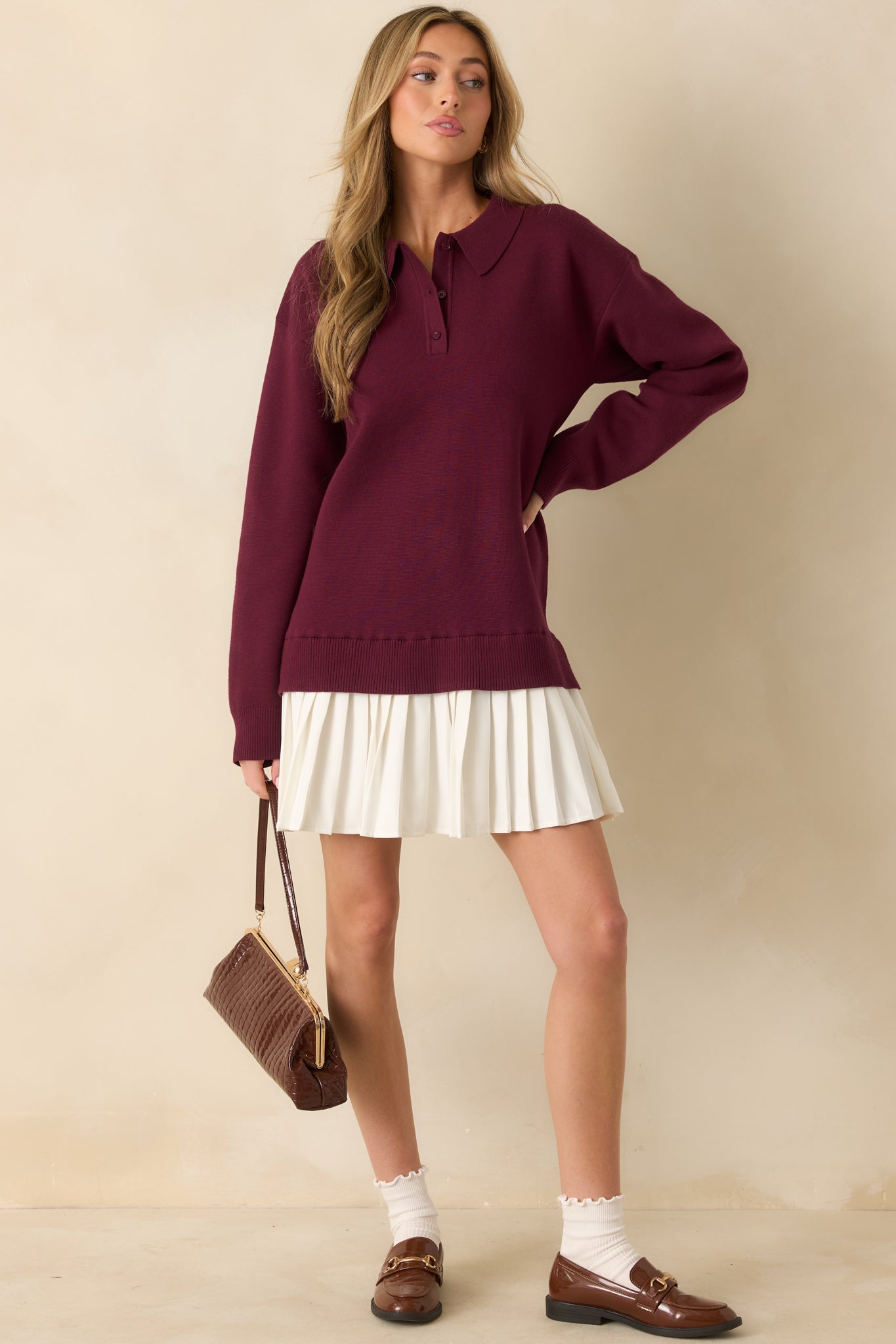 Front view of burgundy sweater mini dress with collared neckline, partial button-front placket, and long sleeves.