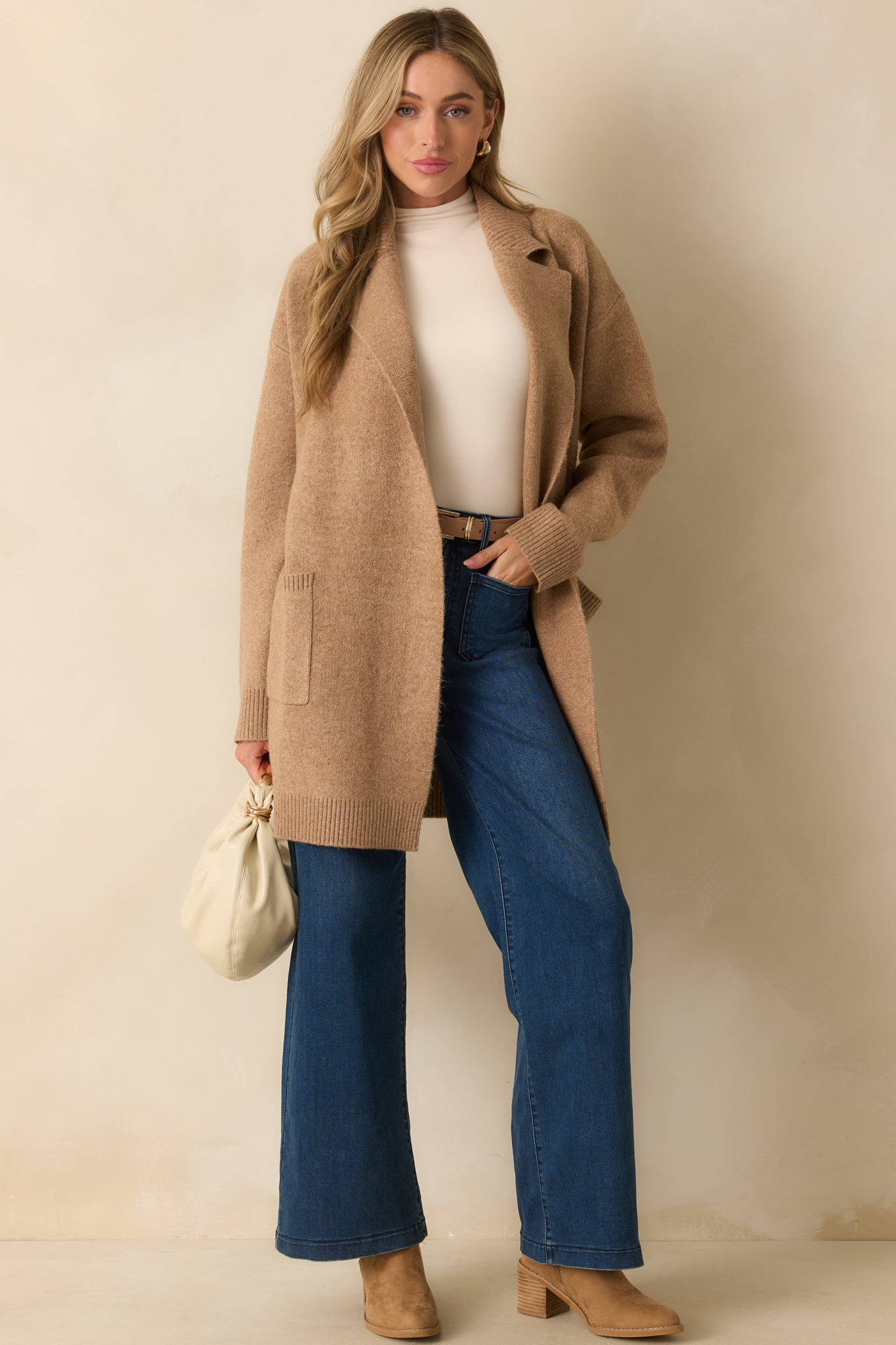 Front view of cardigan featuring long sleeves with ribbed cuffs and functional patch pockets.