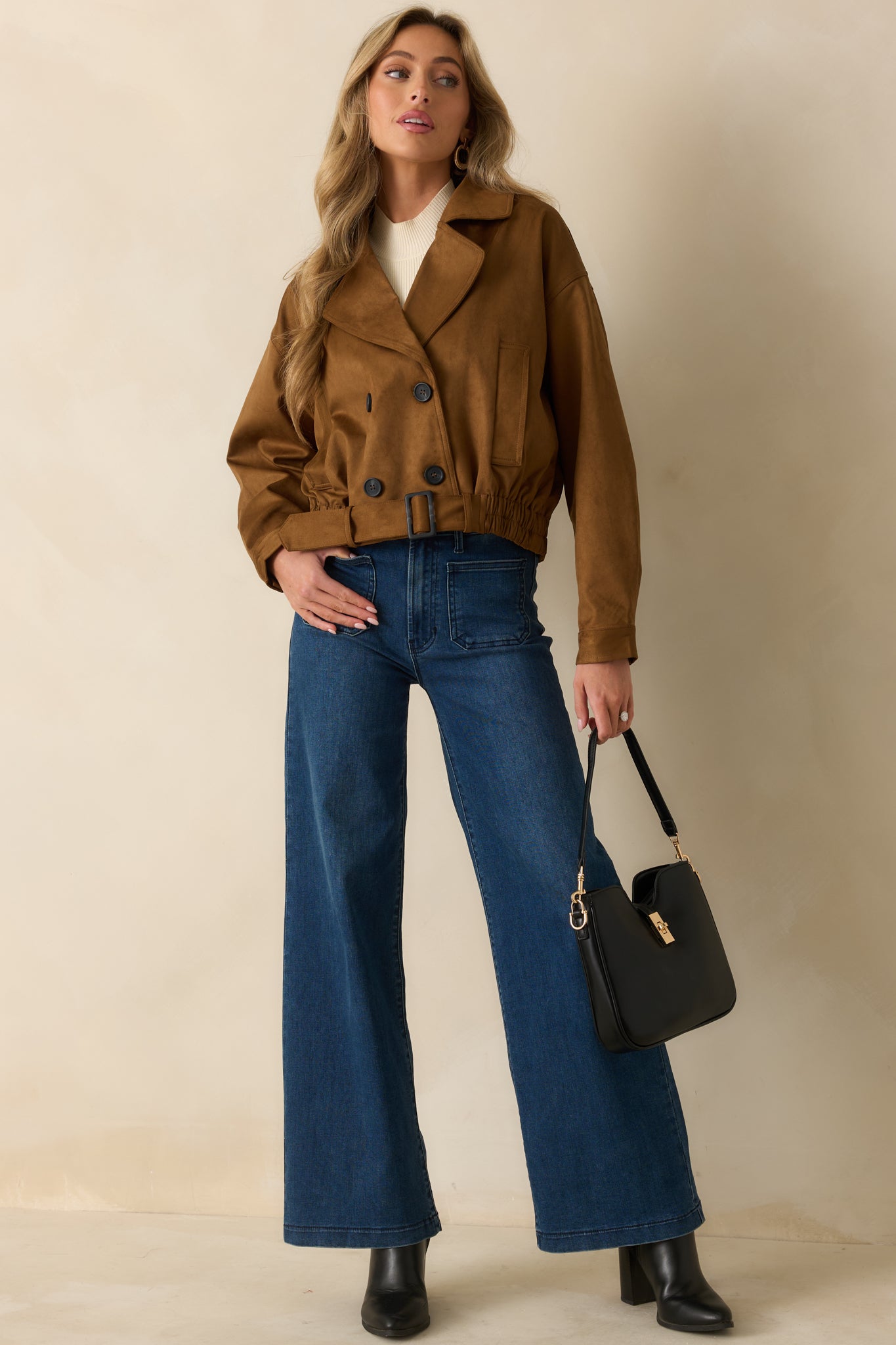 Front view of a cropped camel trench coat, showing elasticized hem, front pockets, and structured double-breasted design.