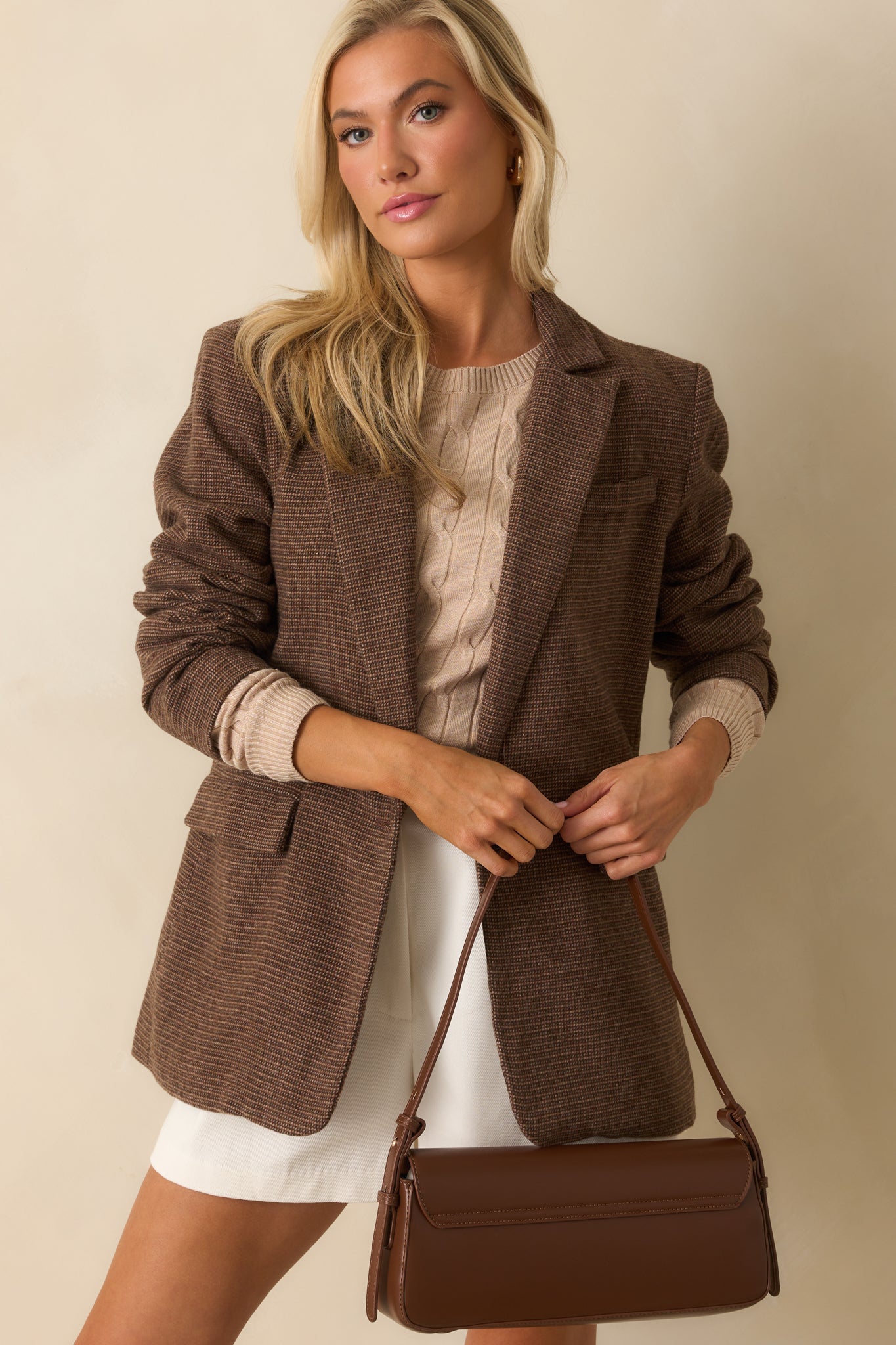 Front view of handbag featuring magnetic flap closures and sleek rectangular silhouette.