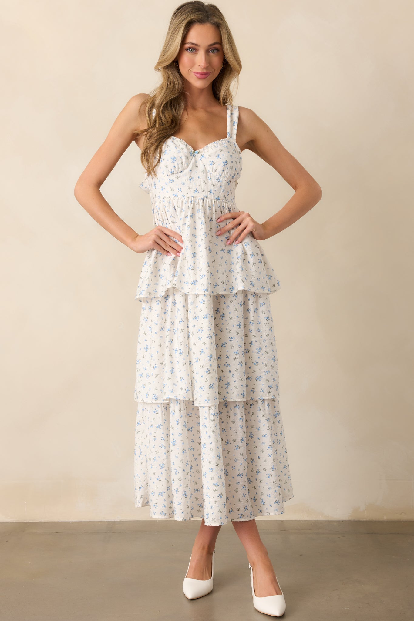 Front-facing view of the blue floral maxi dress, highlighting the bustier-style stitch detailing in the bodice, elastic sweetheart neckline, and tiered skirt. The small center flower and scalloped neckline trim add delicate details.