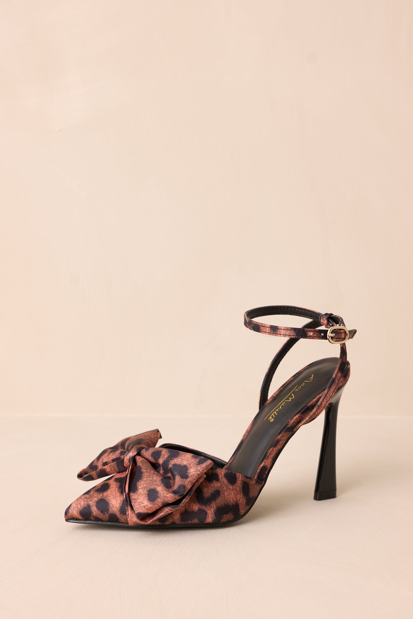 Cropped front view of the leopard print heels featuring a pointed toe and bow embellishment across the toes.