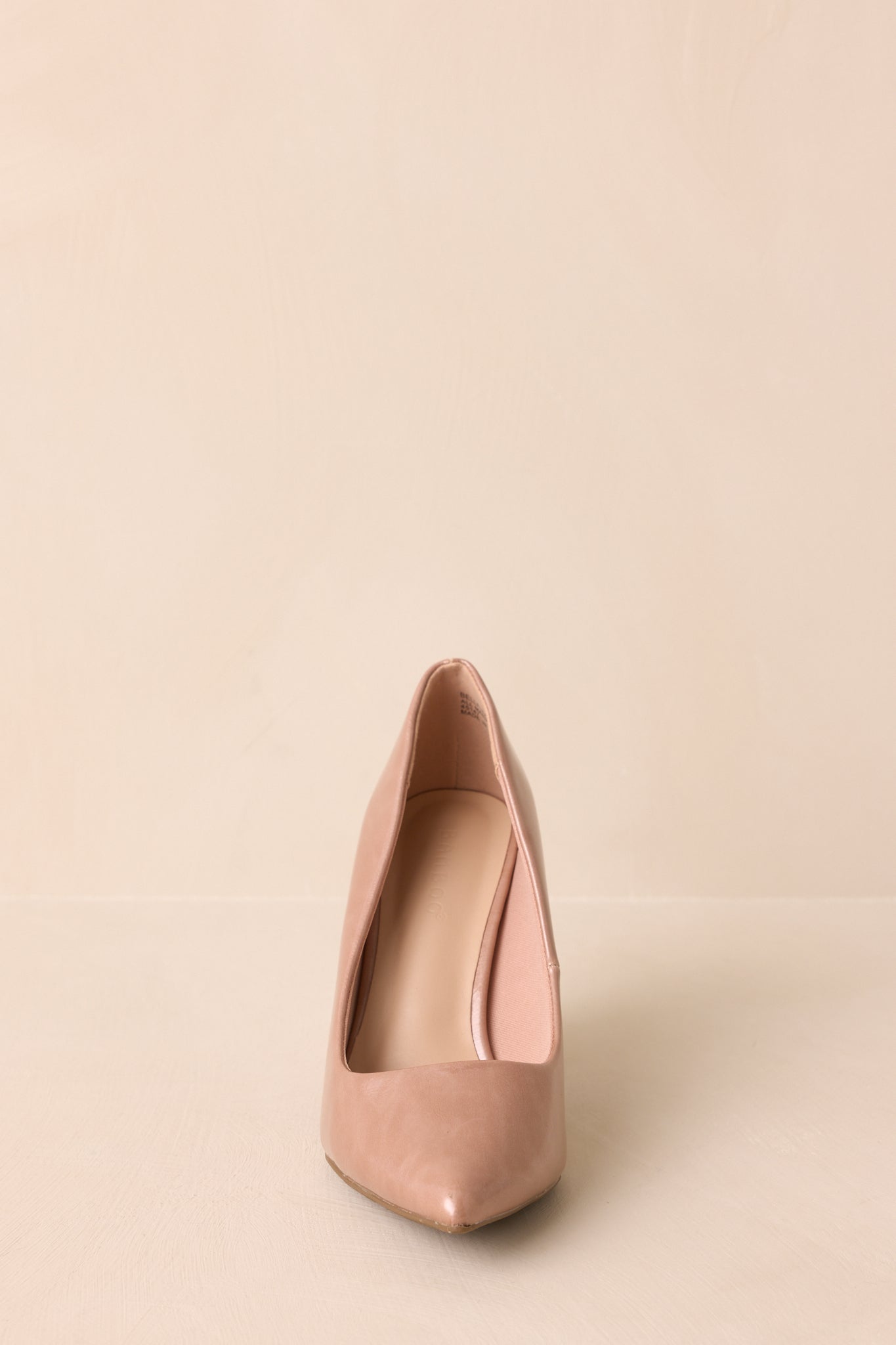Front-facing view of light mocha pump emphasizing pointed toe and polished finish.