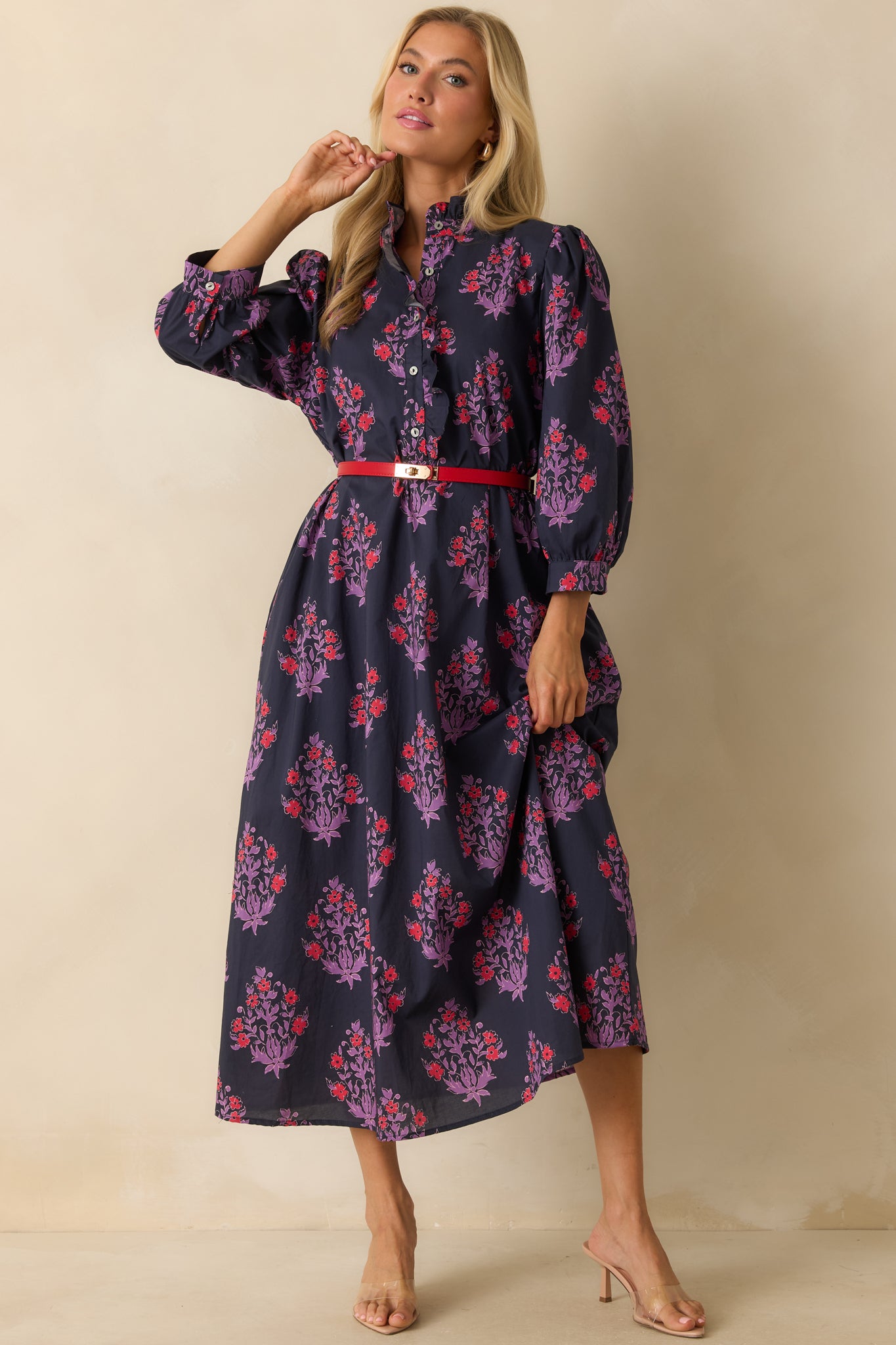 Front view of the maxi dress highlighting the puffed long sleeves, high ruffled neckline, and flowing A-line silhouette.