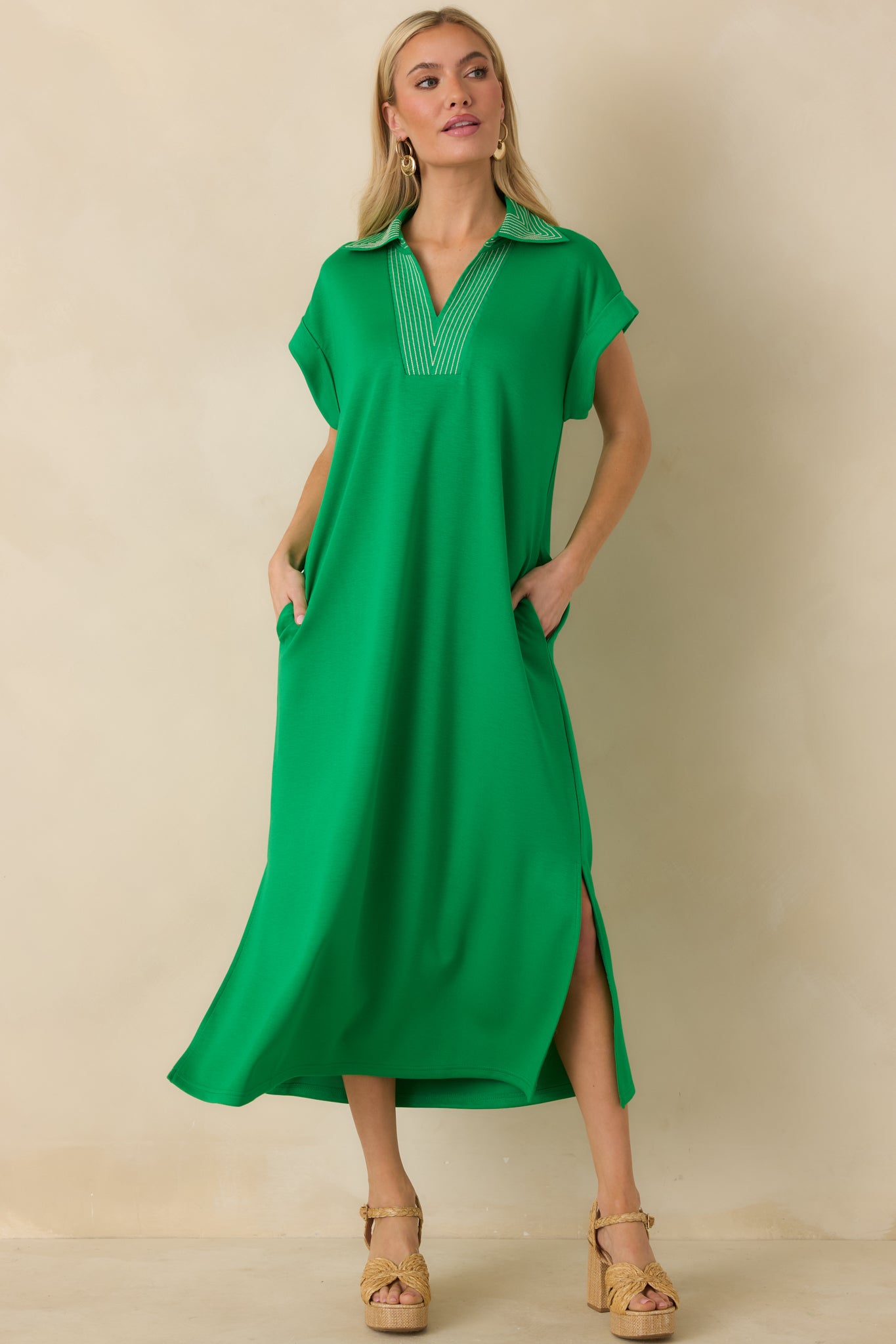 Front view of green midi dress featuring short sleeves and subtle side slits.