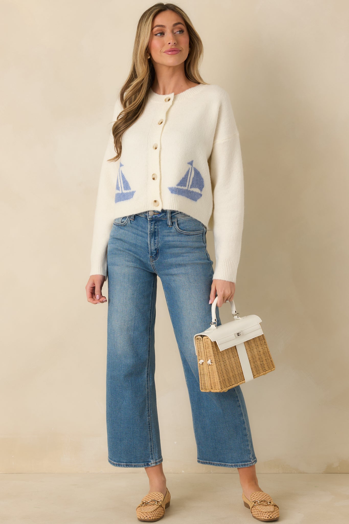 Front view of ivory knit cardigan with classic round neckline and relaxed, slightly cropped fit.