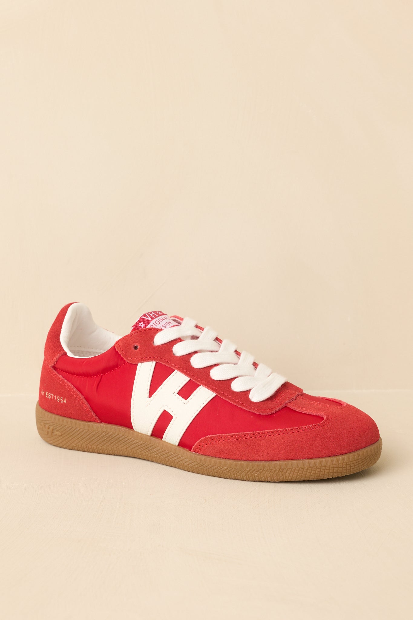 Front view of red sneakers displaying lace-up design and bold color finish.