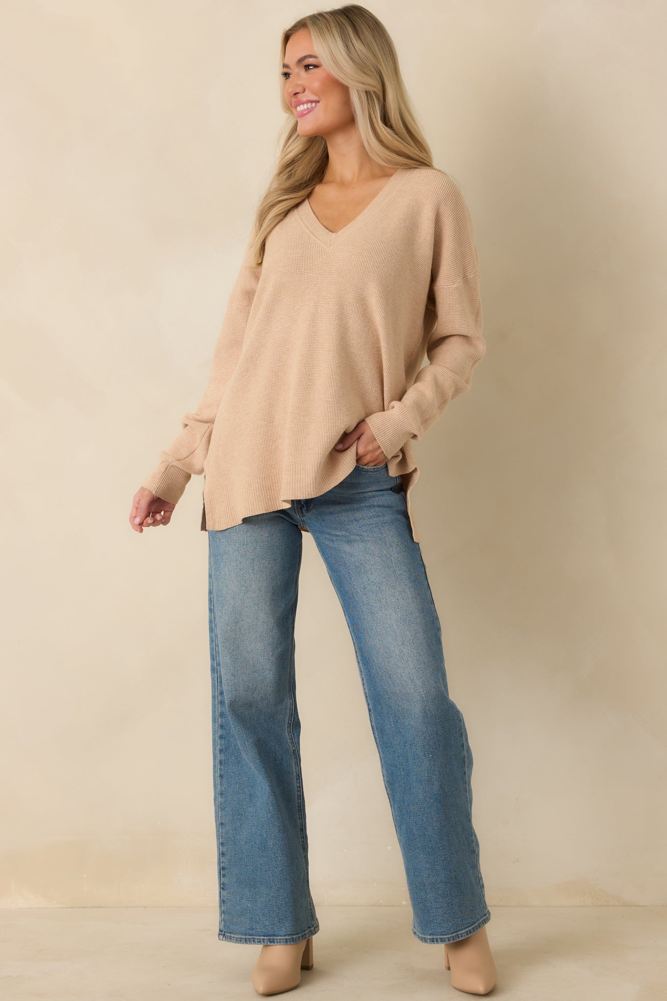 Front view of taupe V-neck sweater featuring ribbed cuffs, loose silhouette, and casual style.