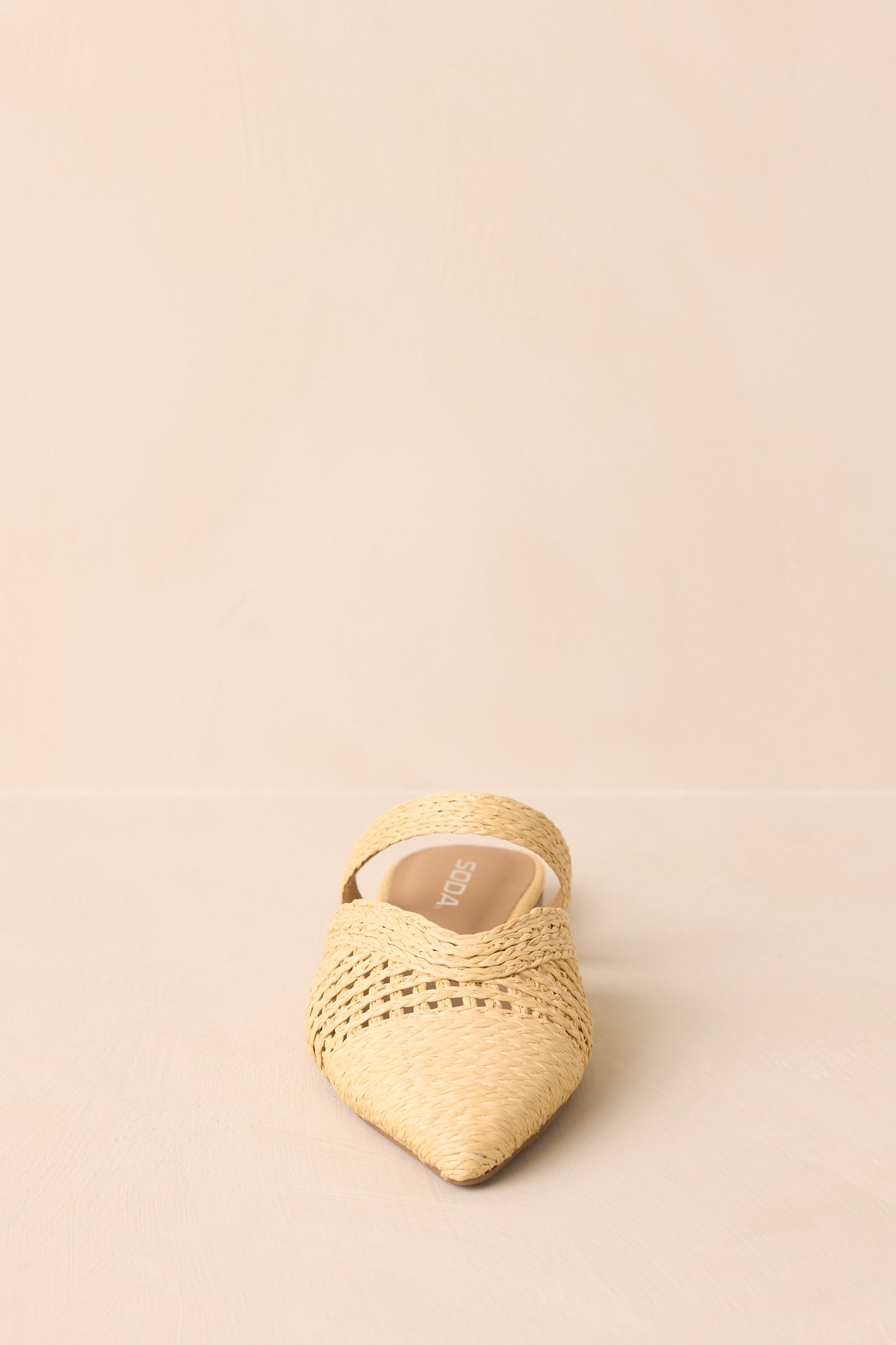 Front view of the flats displayed on a beige background showing the pointed-toe shape and woven upper.