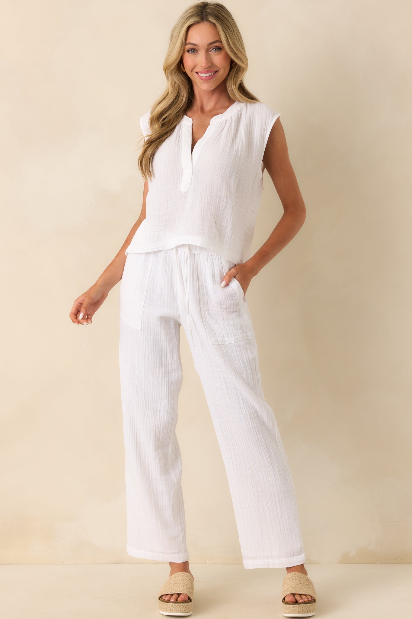 A front view of the white pants showing the high rise fit and ankle length silhouette.