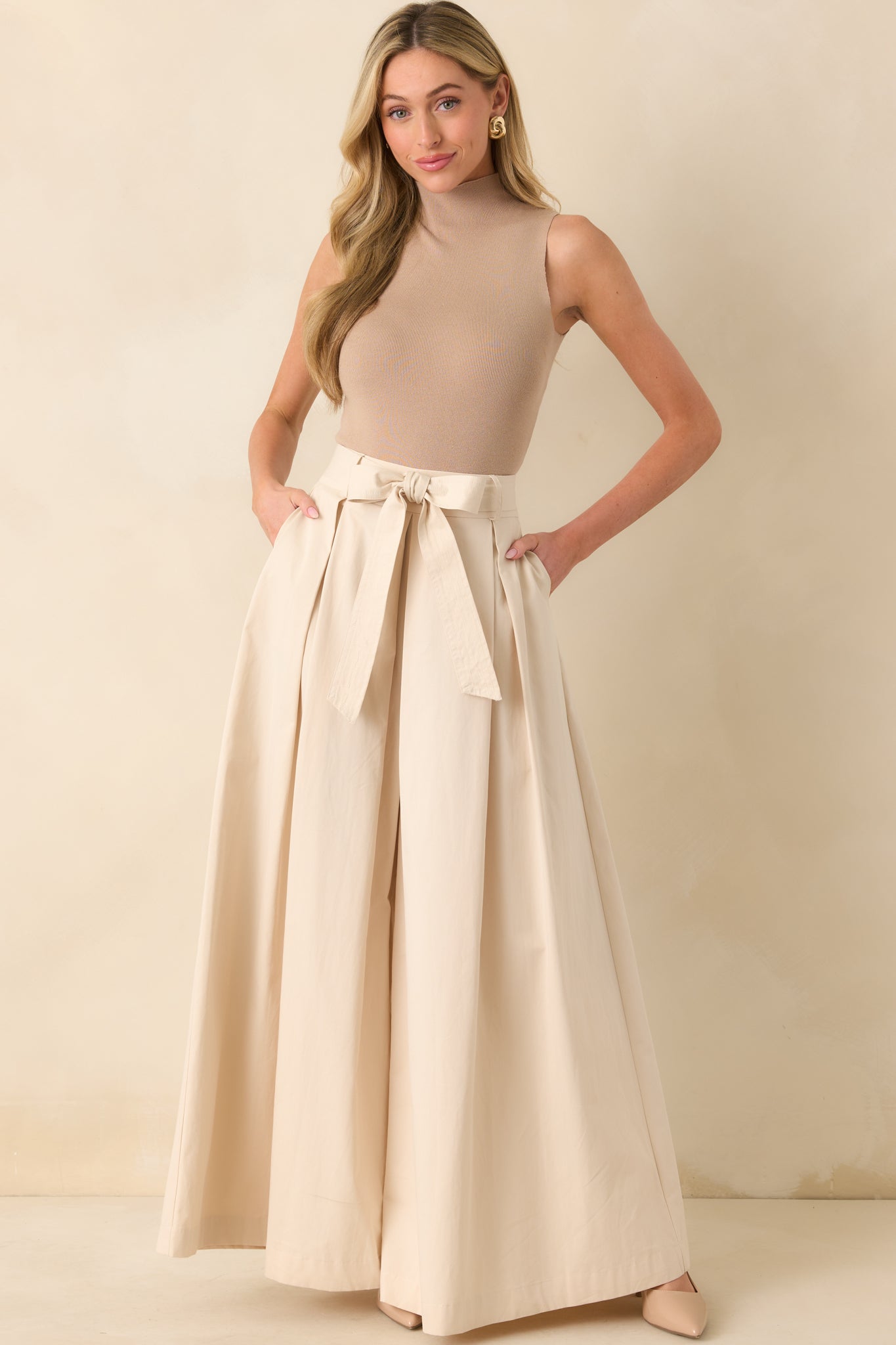 Full body front view of the ecru pants showcasing the high waisted fit and wide leg palazzo silhouette.