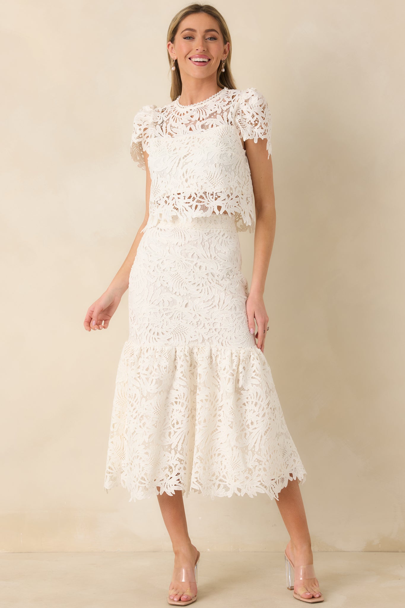 Full-length front view of the ivory lace top showcasing the sheer floral lace overlay and fitted cropped silhouette.