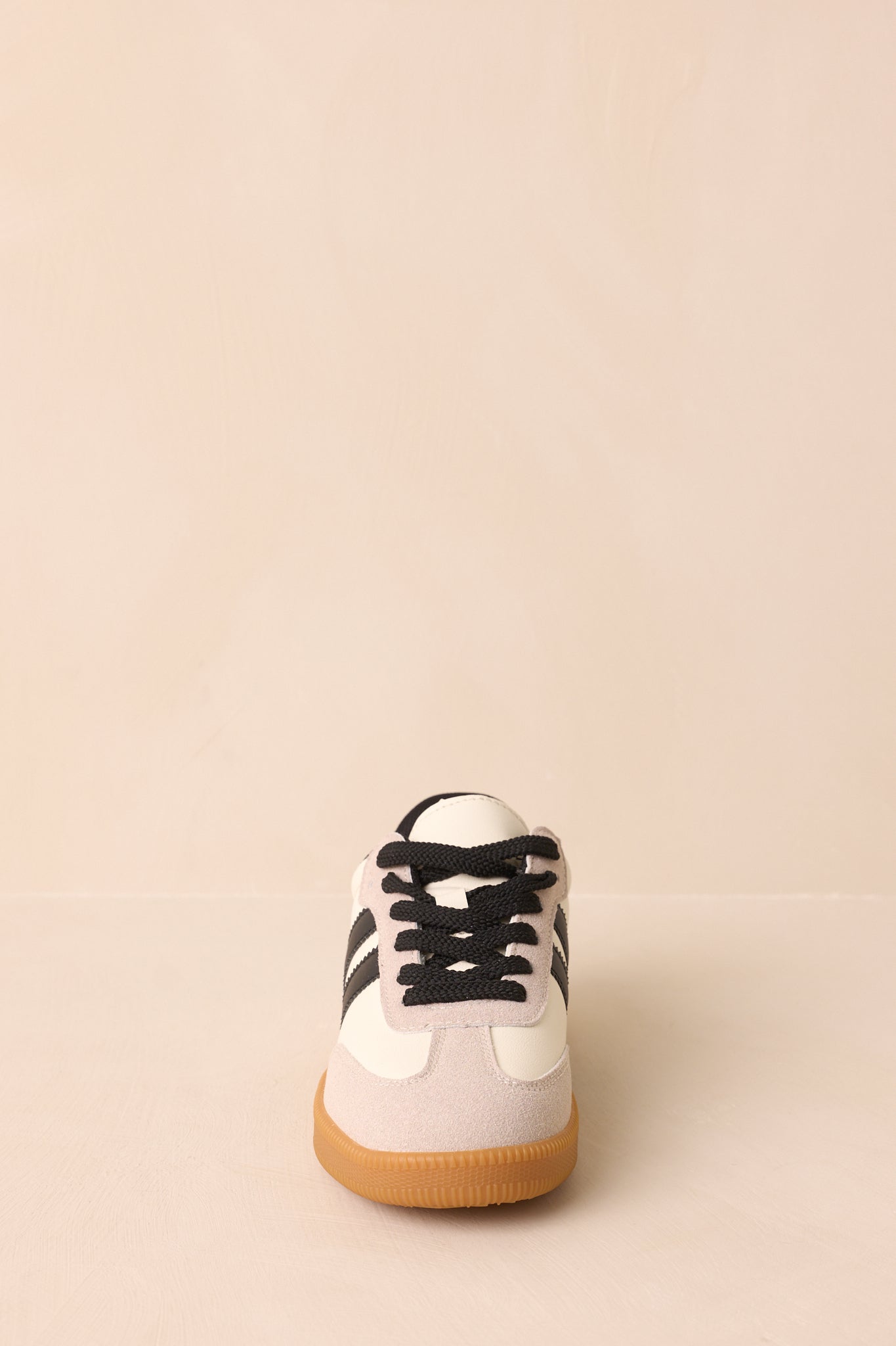 A front-facing view of the sneakers showing the laces, rounded toe, and clean upper texture.