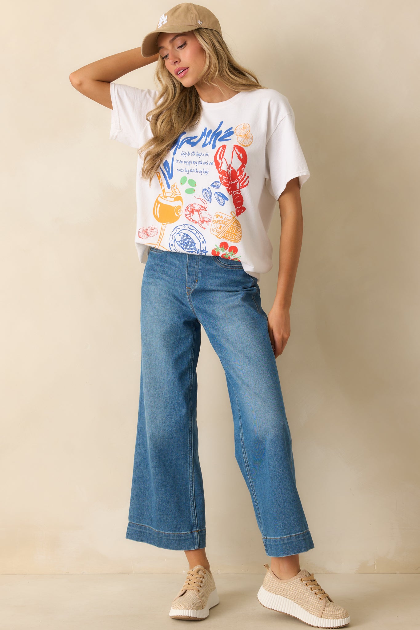 Slightly angled front view of the white tee showcasing lightweight fabric and bold coastal-inspired print.