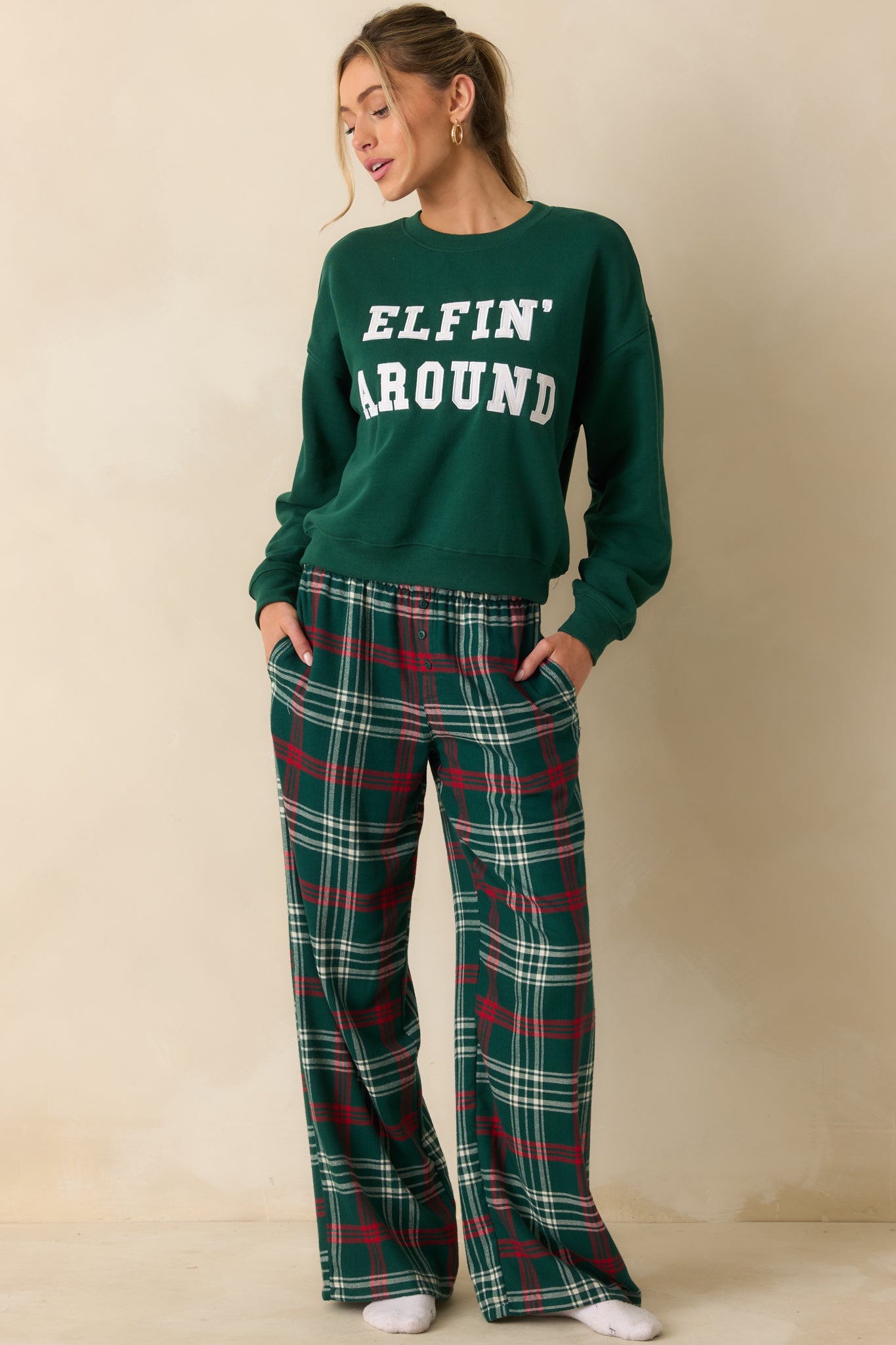Front view of oversized green sweatshirt, highlighting crew neckline, cozy fleece fabric, and playful holiday-themed twill applique.