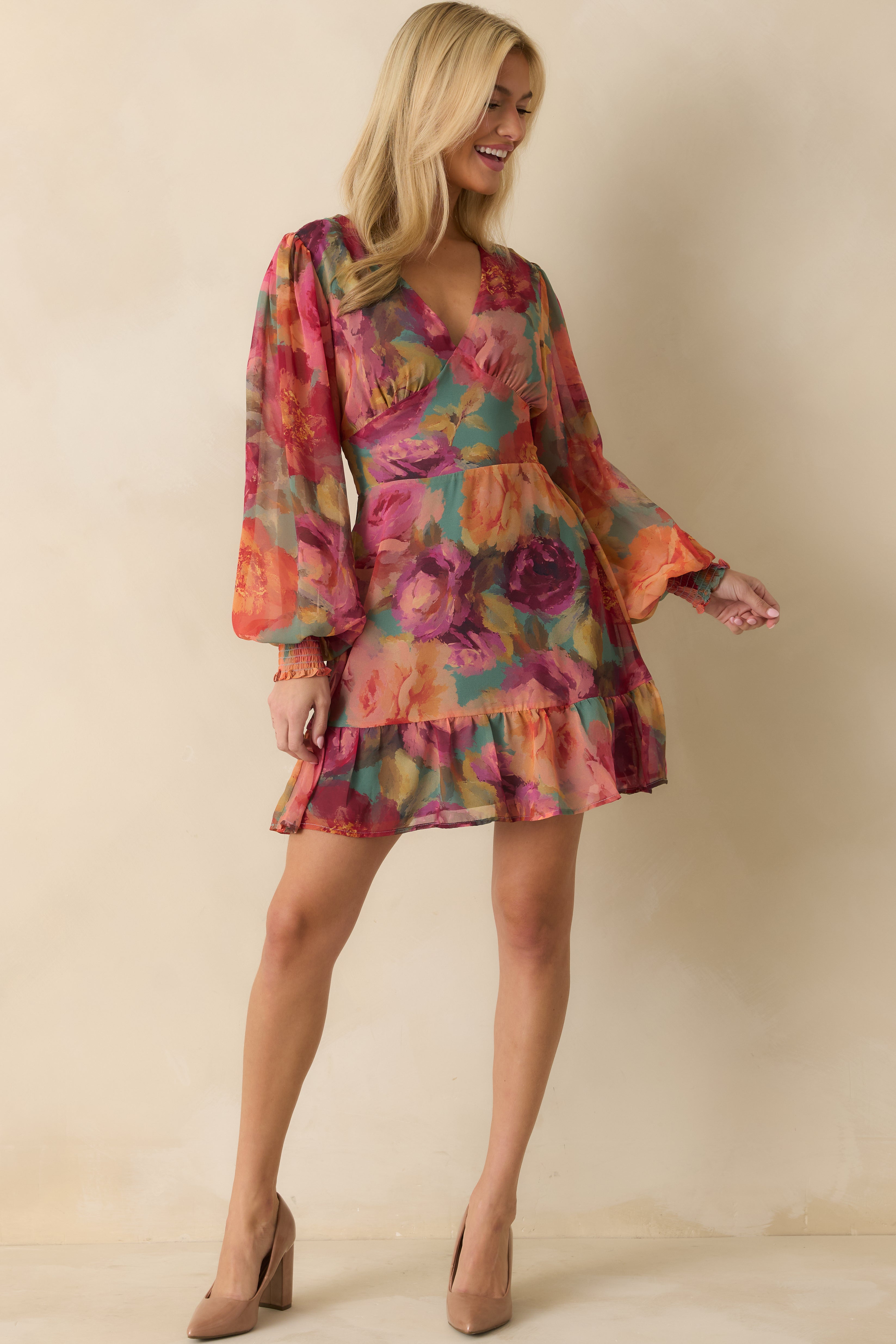 Front view of the pink multi floral chiffon mini dress showing the V-neckline, long sheer sleeves, and tiered hem.