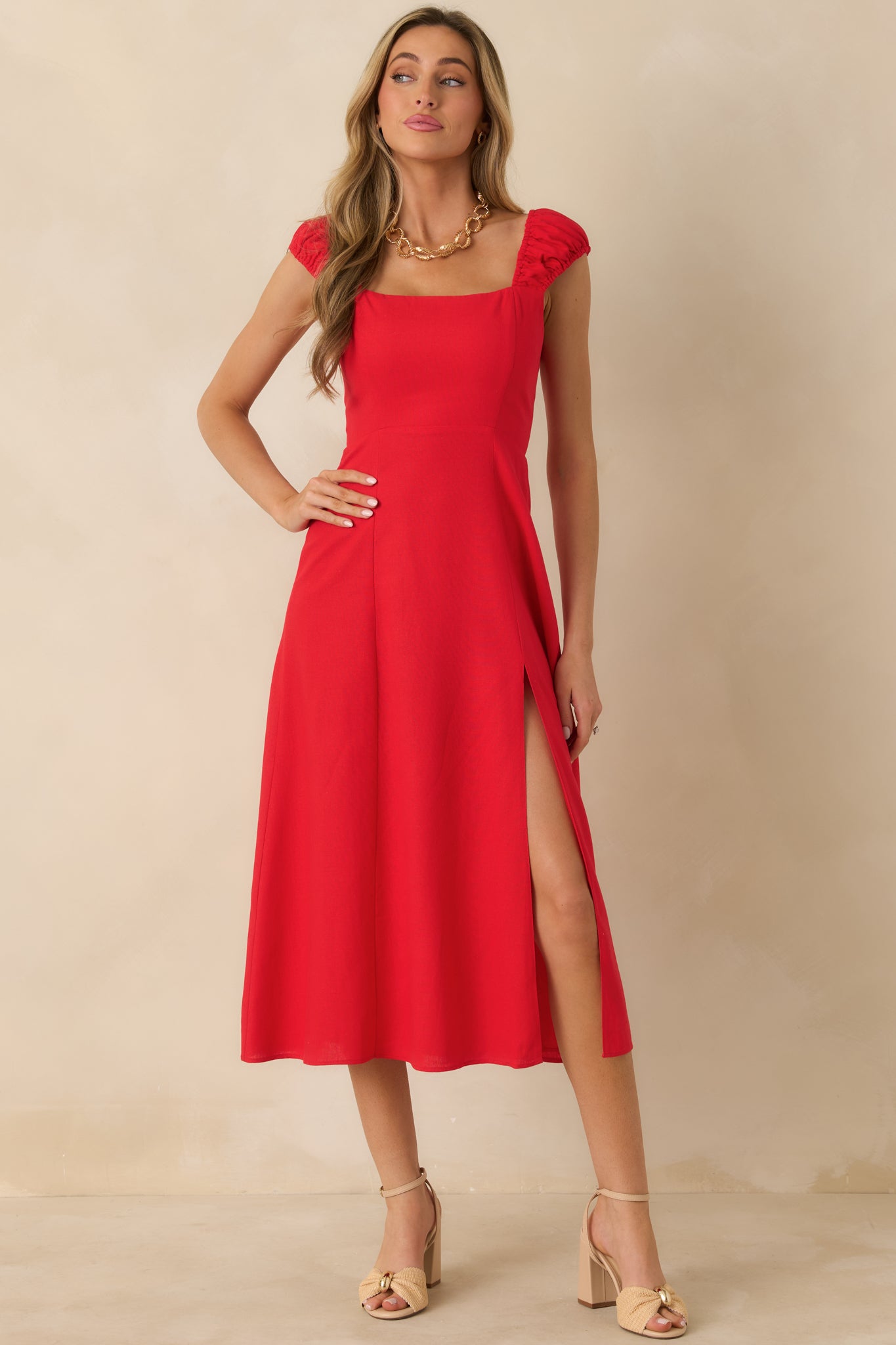 Front view of red midi dress showing square neckline, flowy skirt, and leg slit.