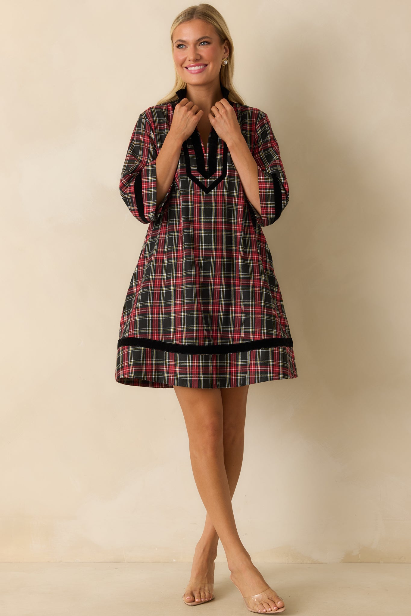 Front view of red plaid dress featuring soft woven fabric, black velvet trim, and flowing mini-length silhouette.