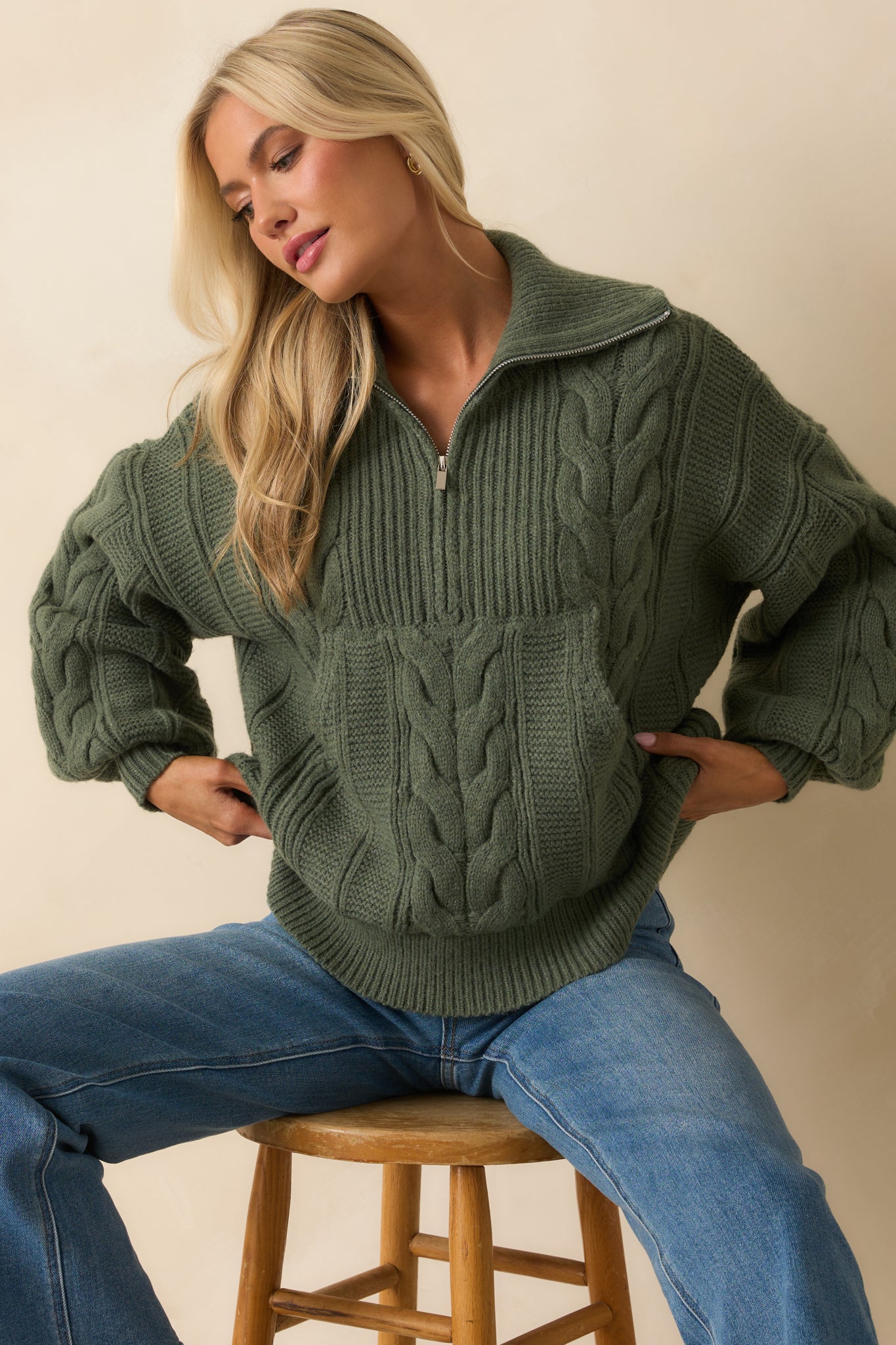 A cropped front view showing the cable knit texture and relaxed sleeve design.