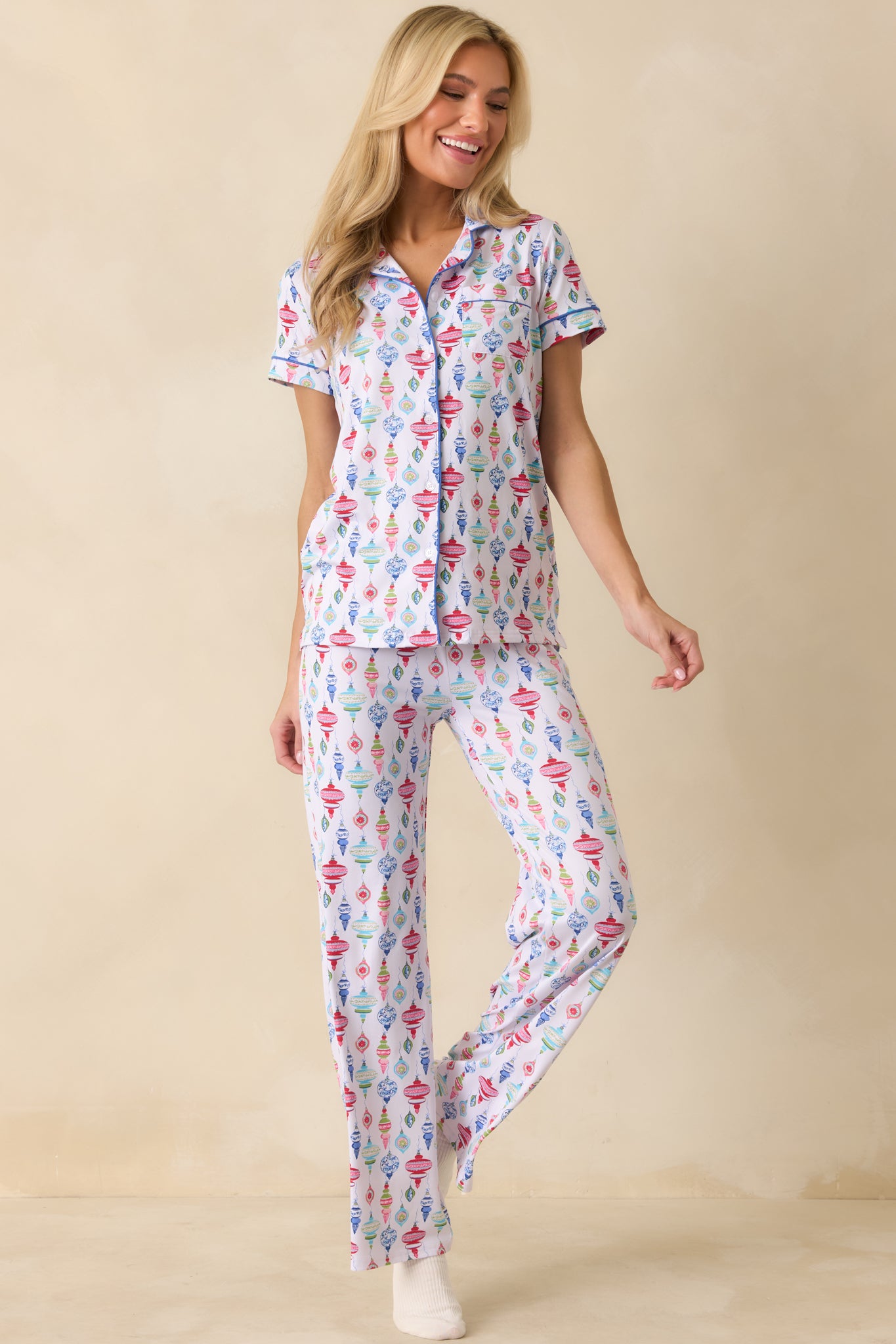 Front view of the white pajama pants showing the colorful ornament print and relaxed straight-leg fit.