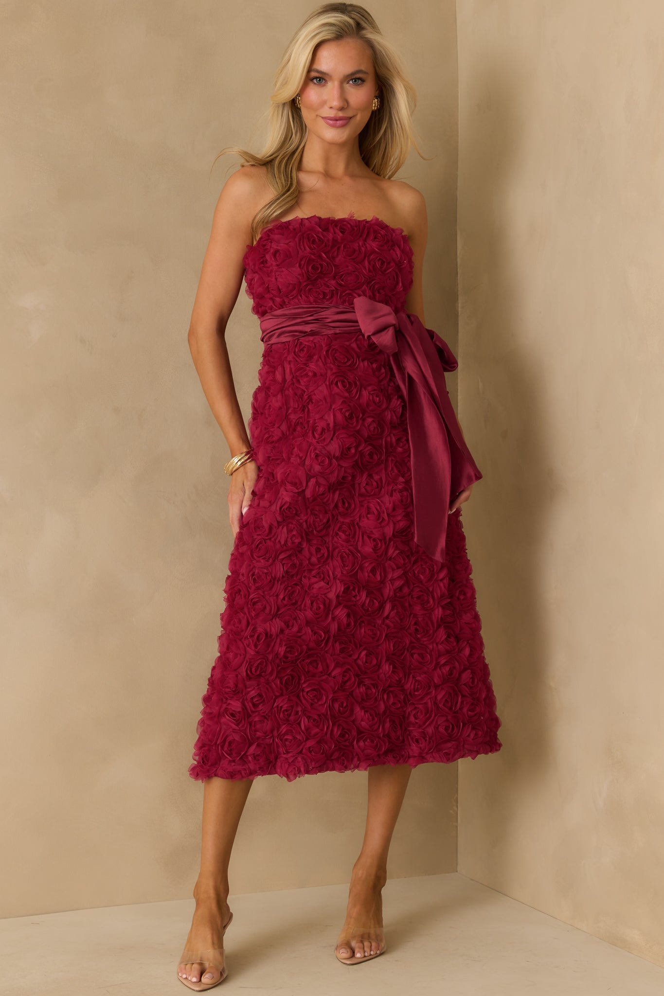 Front view of wine strapless dress with floral applique and midi length.