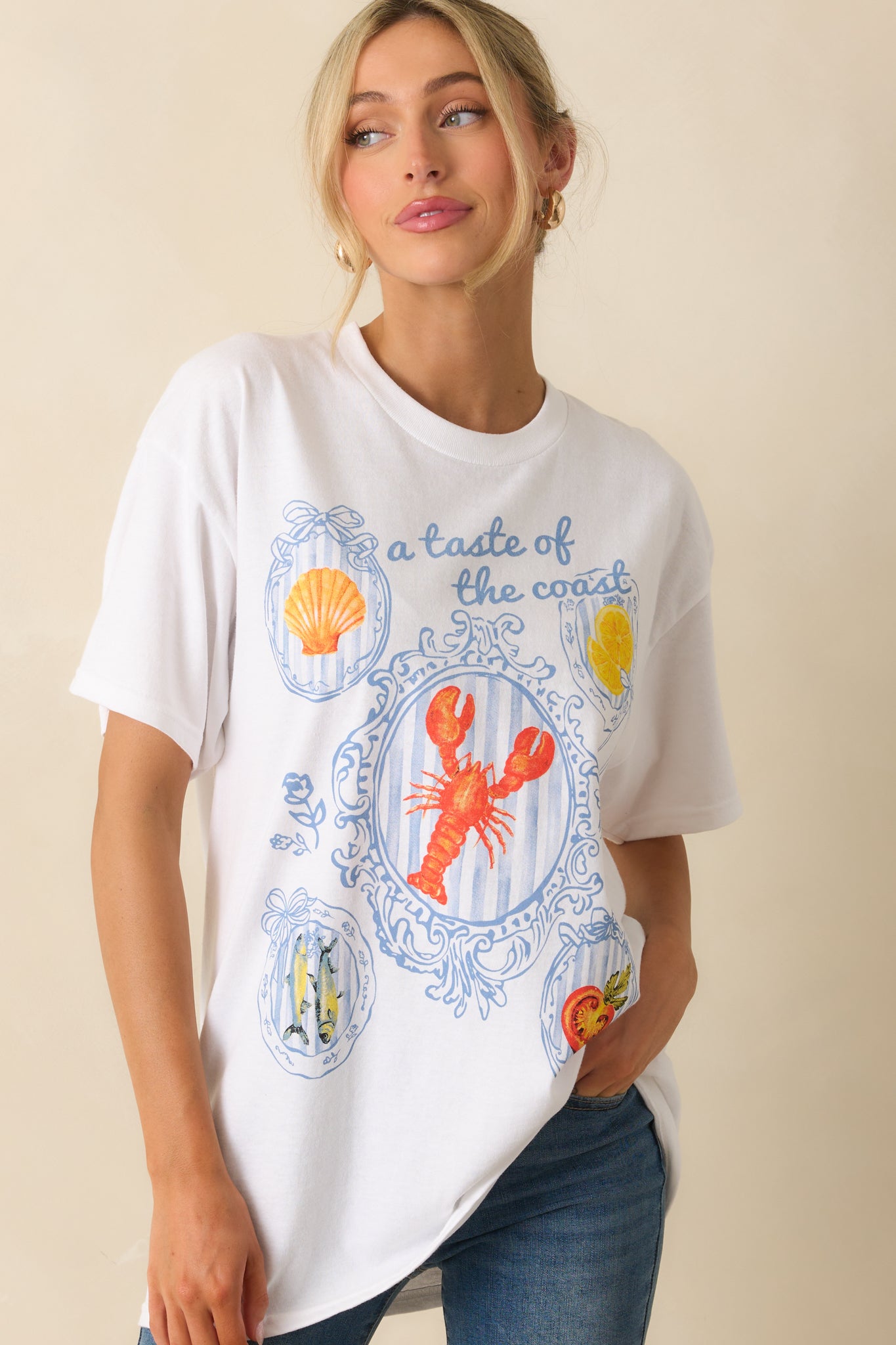 White short-sleeve tee displayed from the front with visible relaxed fit and detailed multicolor coastal design.