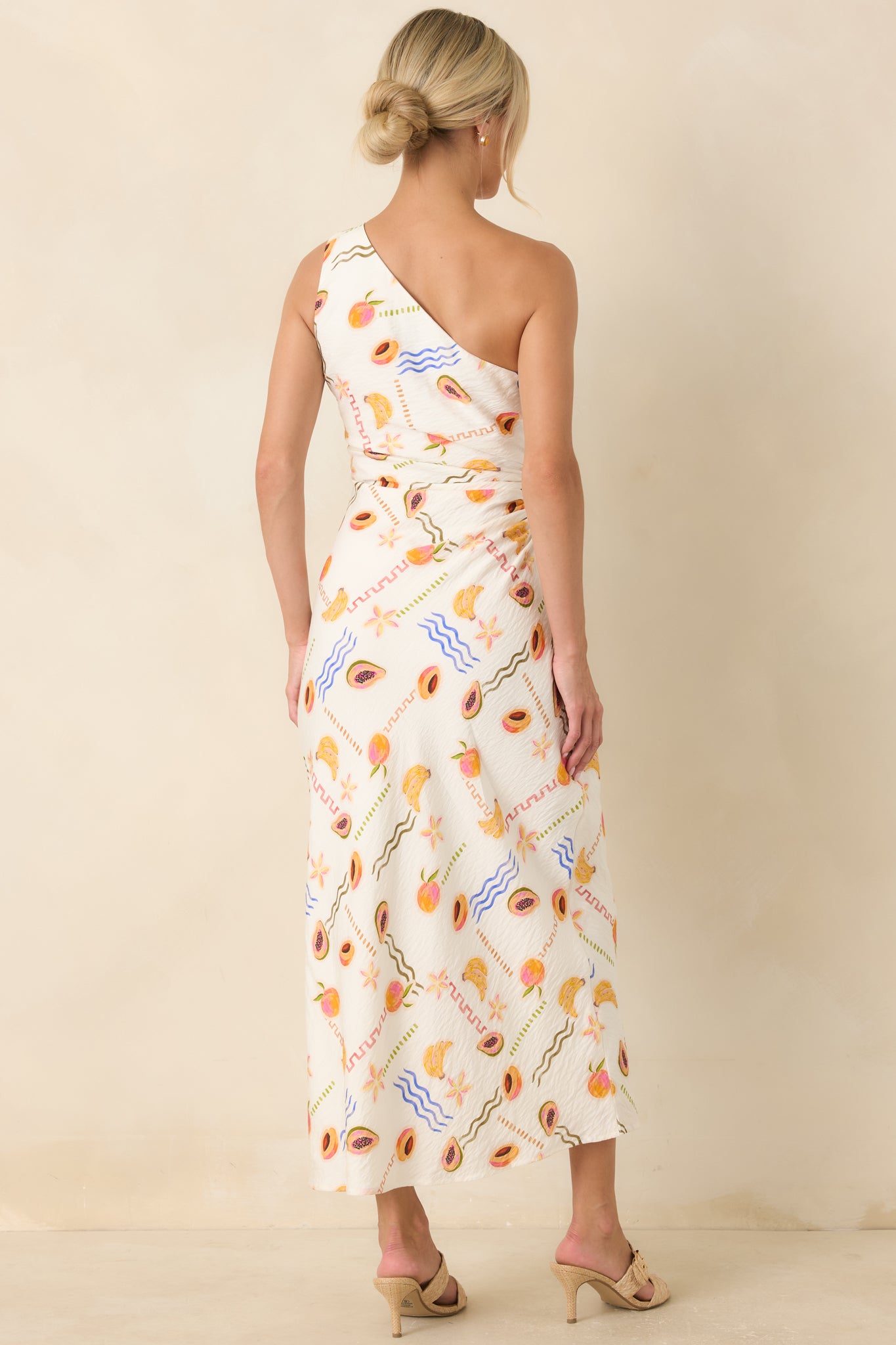 Back of the fruit print maxi dress featuring the asymmetrical design and adjustable side tie detail.