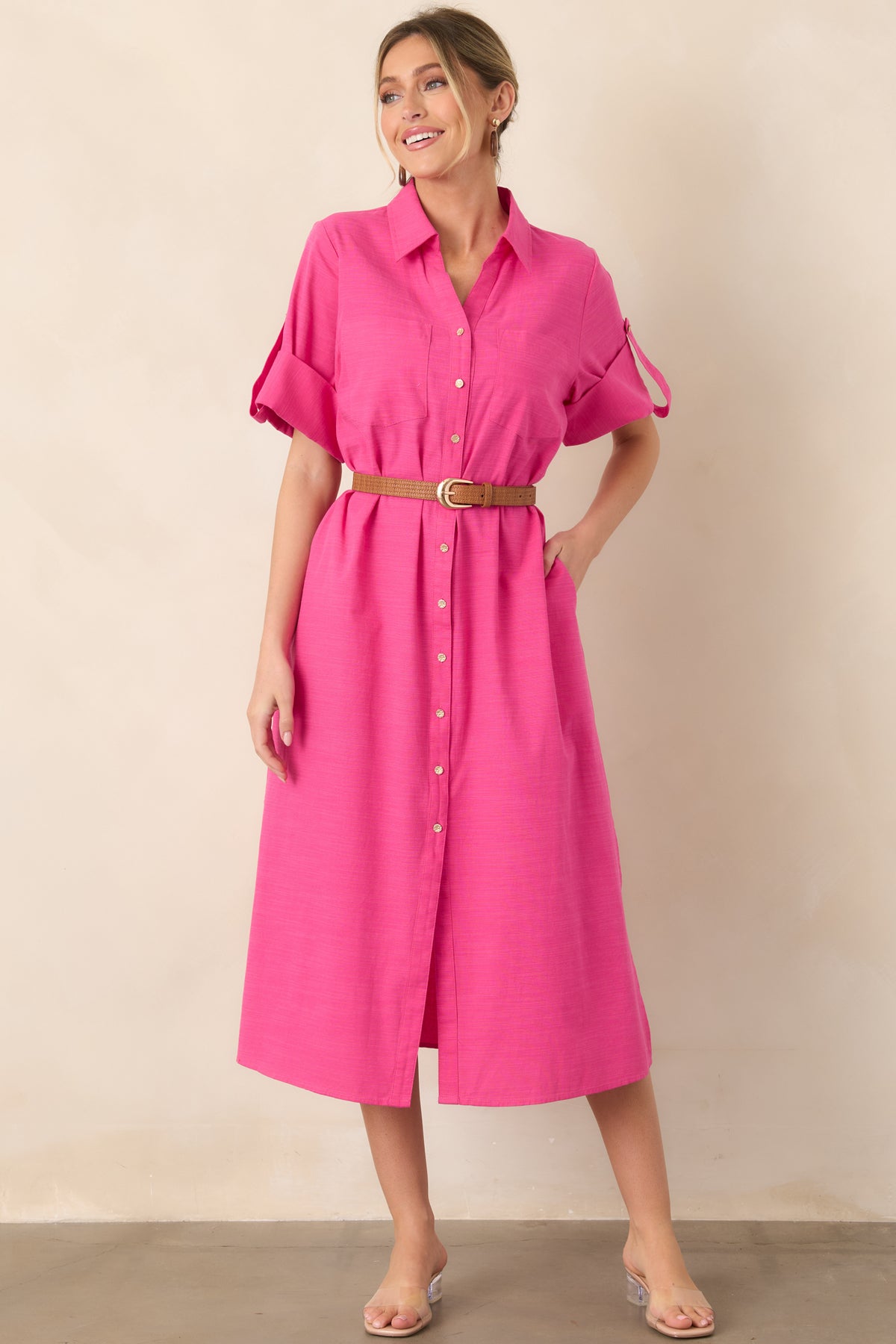 Bright fuchsia shirt dress featuring a classic collar, full row of gold-tone buttons, long sleeves, and an easy straight shape.