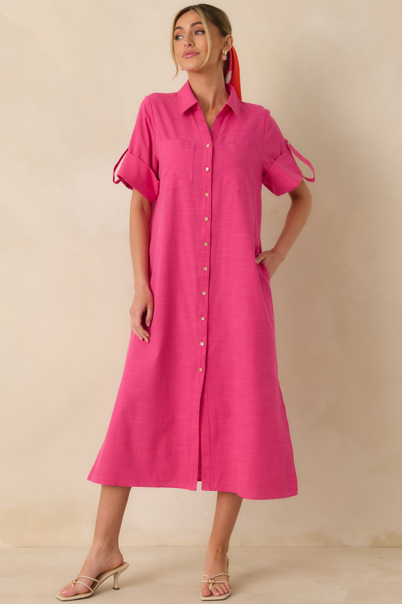Relaxed-fit fuchsia midi shirt dress with a straight silhouette, long sleeves, collared neckline, and gold-tone buttons along the full front.