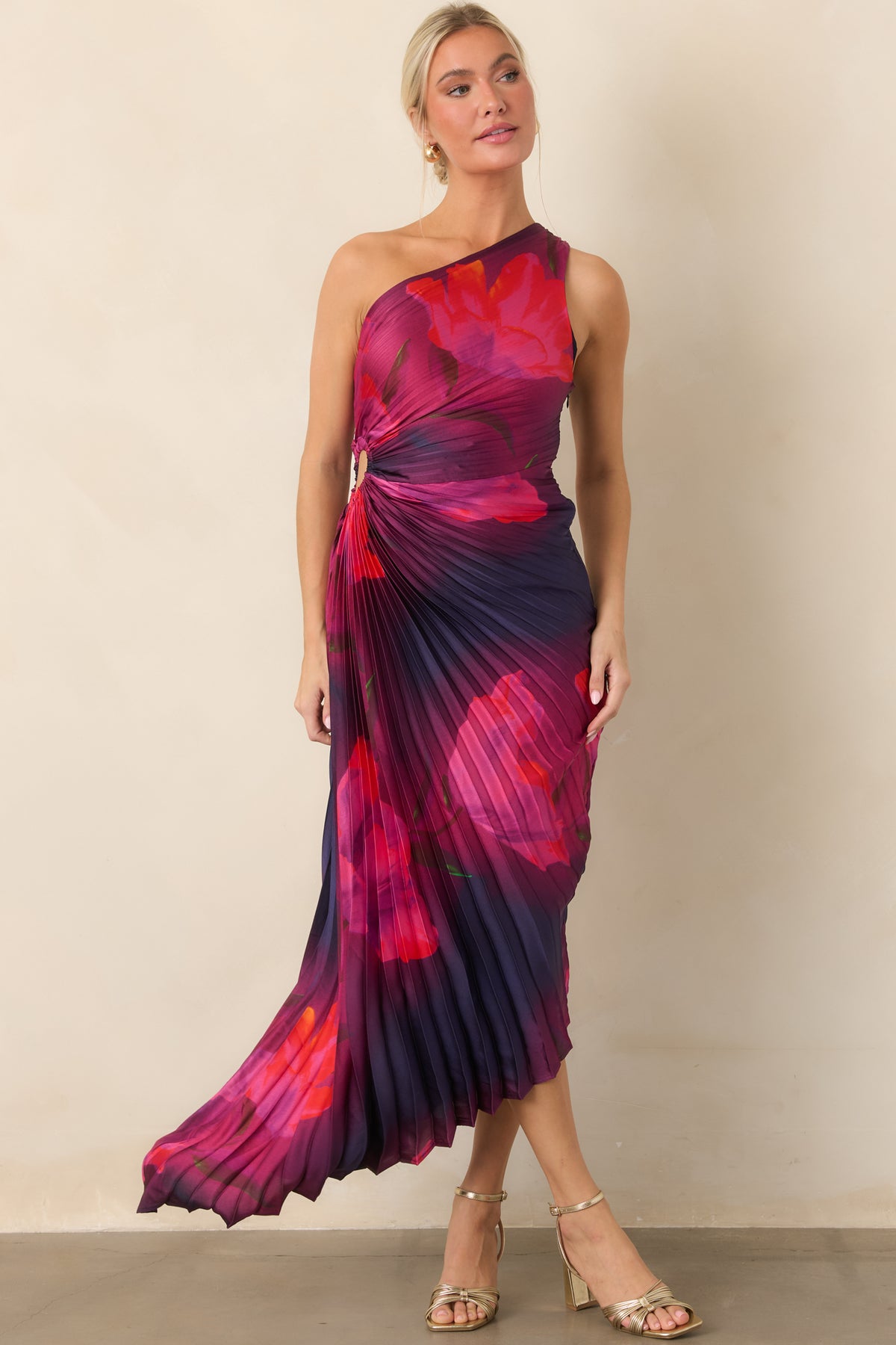Fuchsia and scarlet blooms cover the plum and deep indigo dress, framed by an asymmetrical one-shoulder neckline and sculpted pleating.