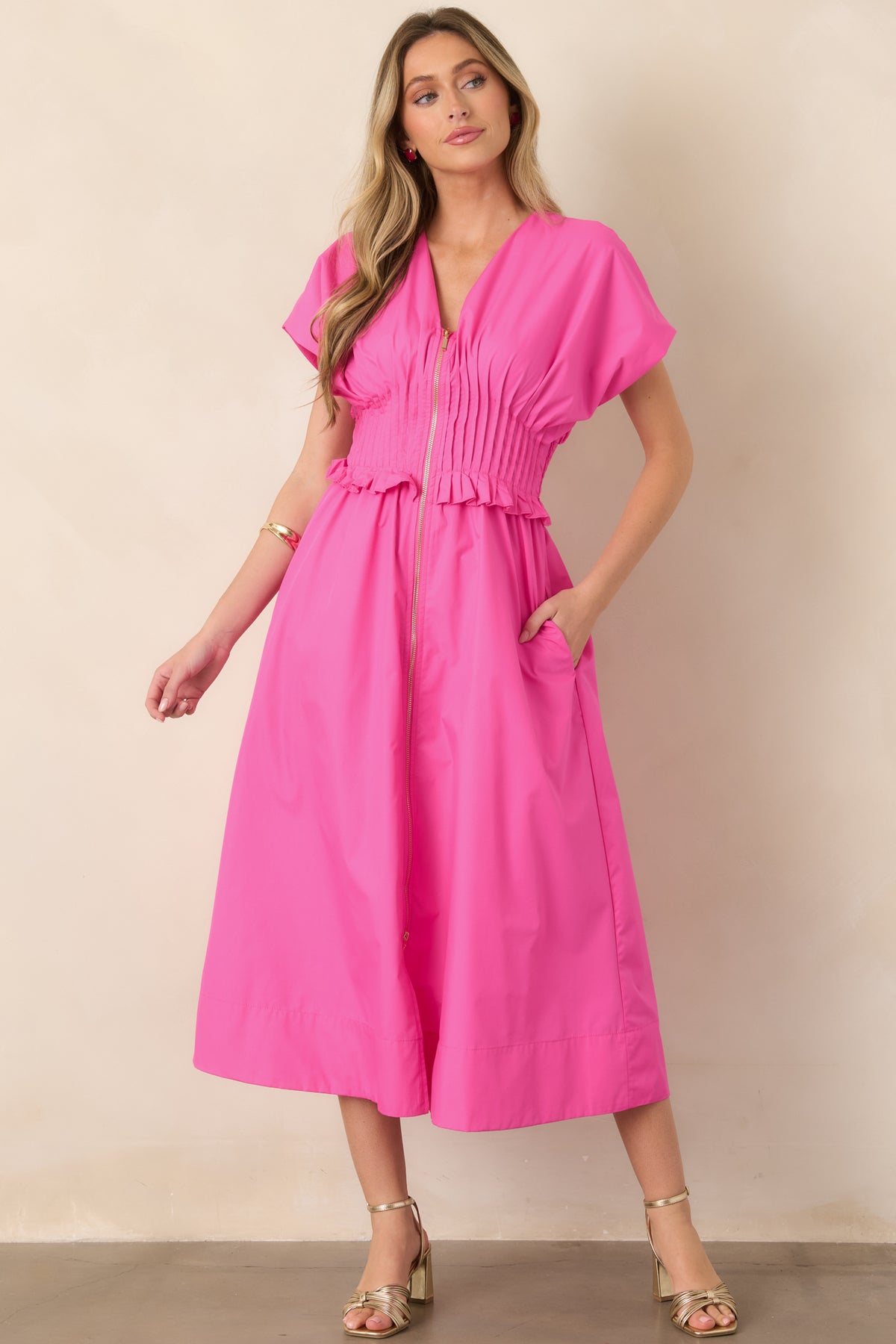 Bright fuchsia maxi dress showcasing short sleeves, a wide gathered waistband with ruffle trim, side pockets, and an easy flowing shape.
