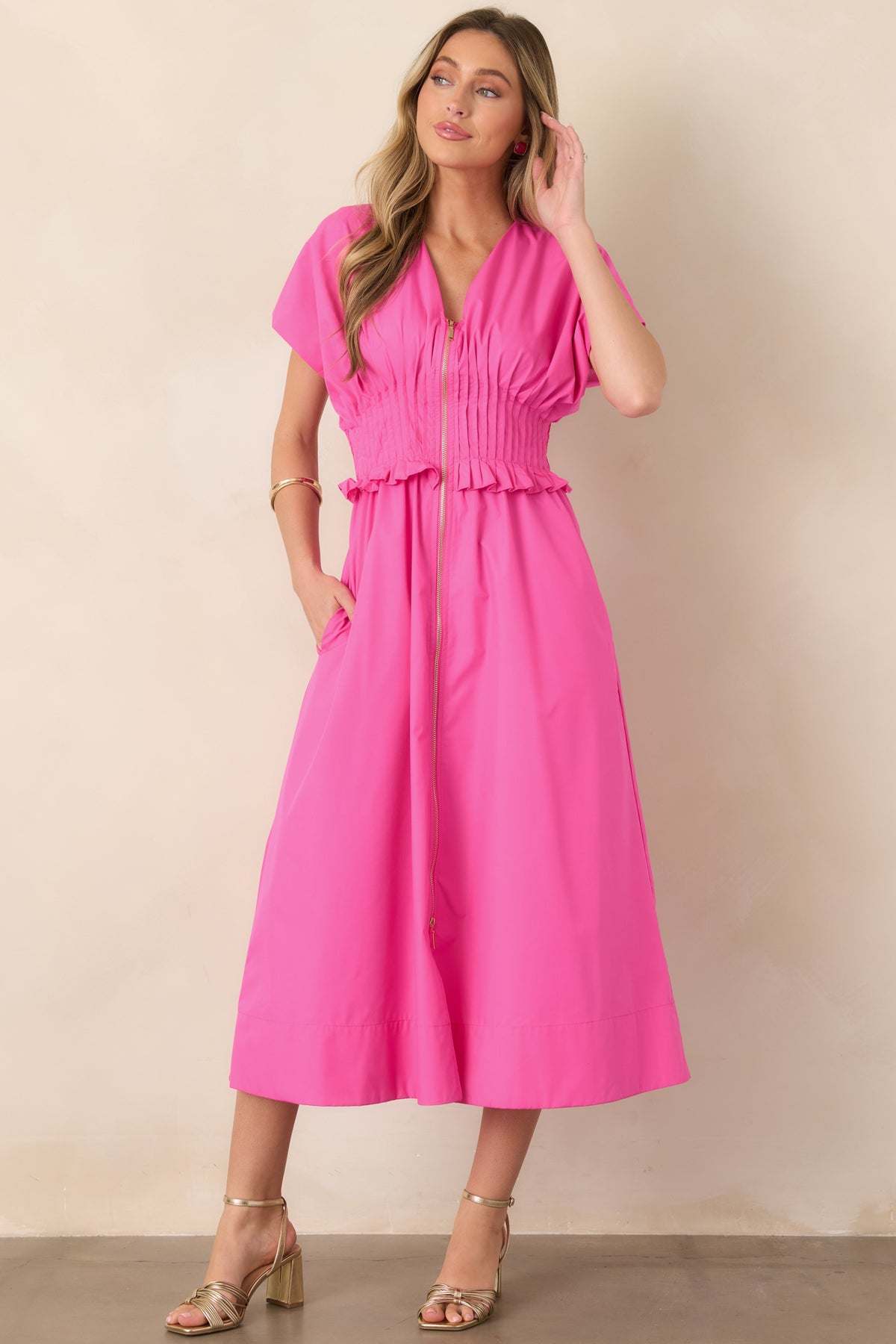 Fuchsia woven maxi dress featuring a flattering V-neckline, short sleeves, ruffle-trimmed smocked waistband, flowing A-line skirt, and side pockets.
