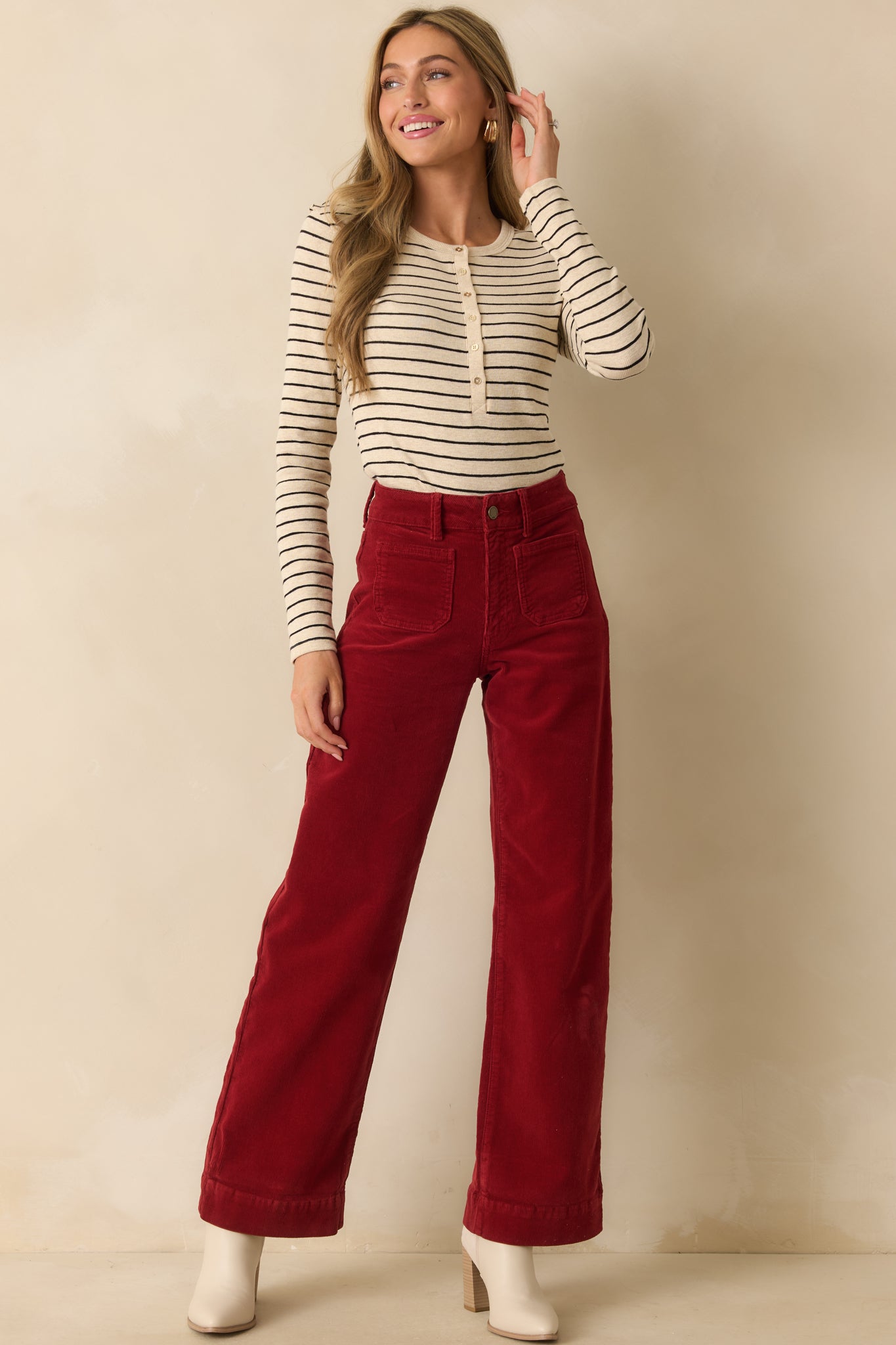 Full body front view of the ivory and black striped Henley top with a fitted silhouette and round neckline.