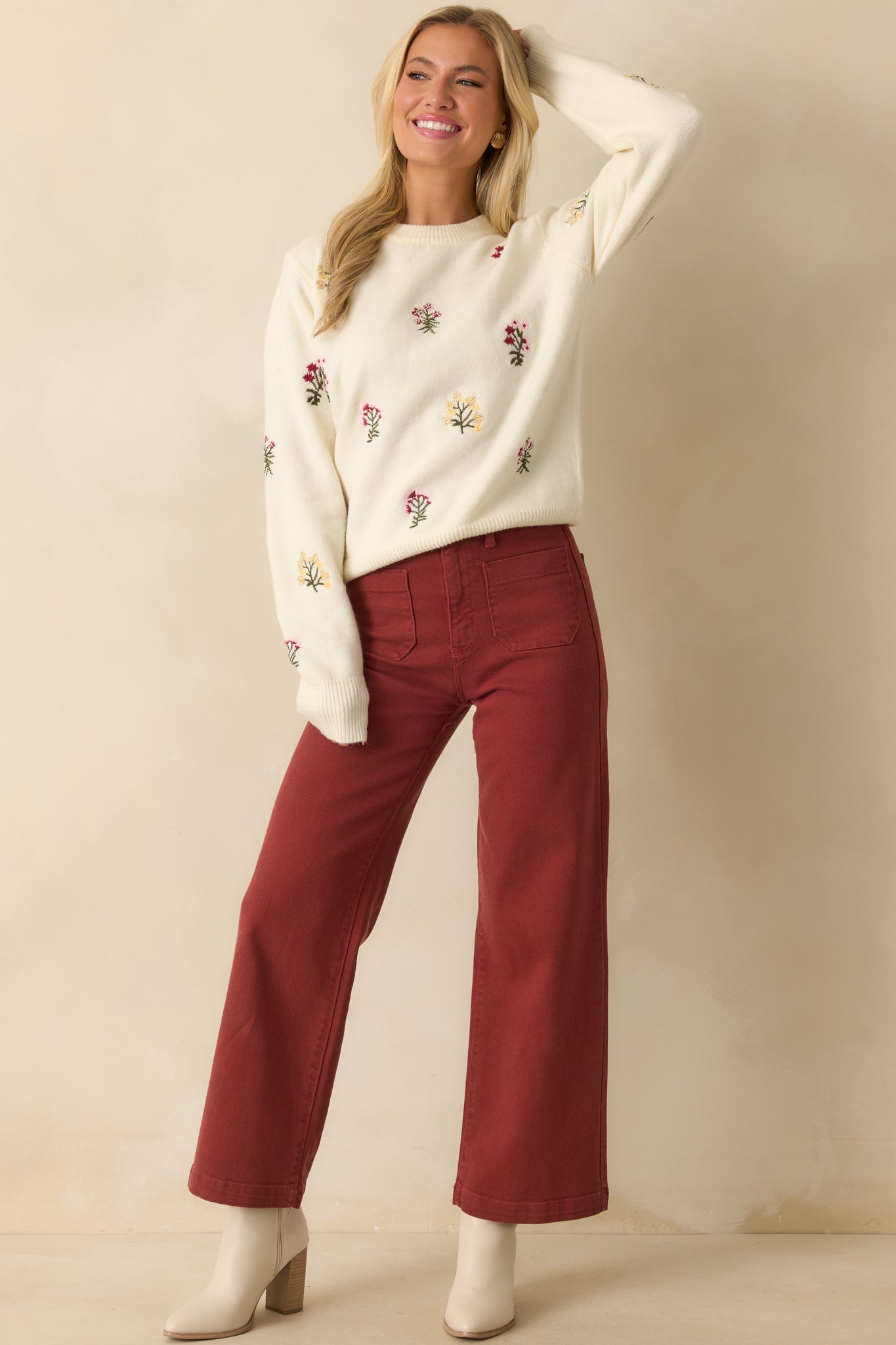 Full body front view showing the relaxed fit and ribbed hems of the embroidered sweater.