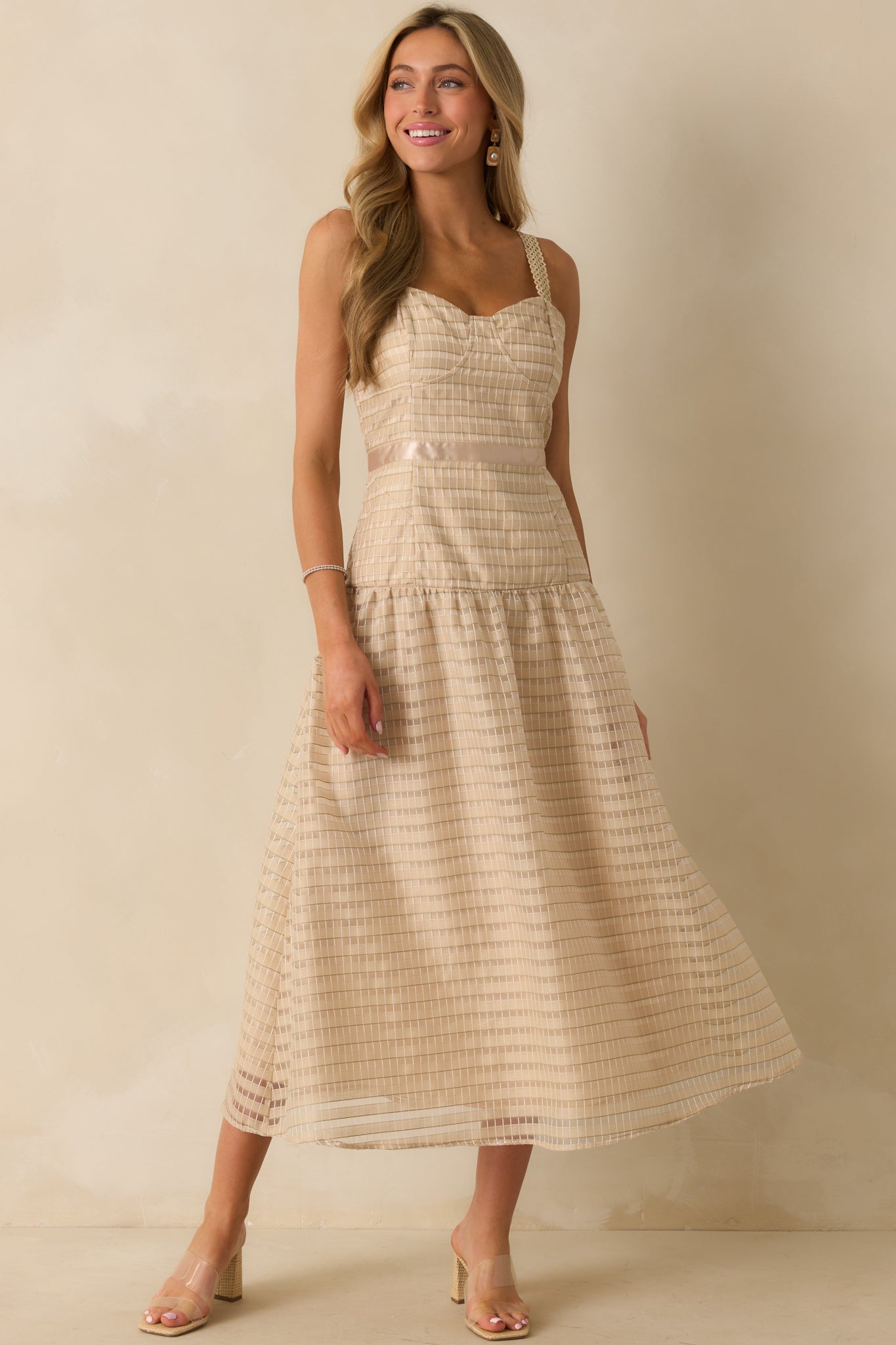 Full body image of the tan dress, emphasizing the fluffy embroidered skirt and structured bust detailing.