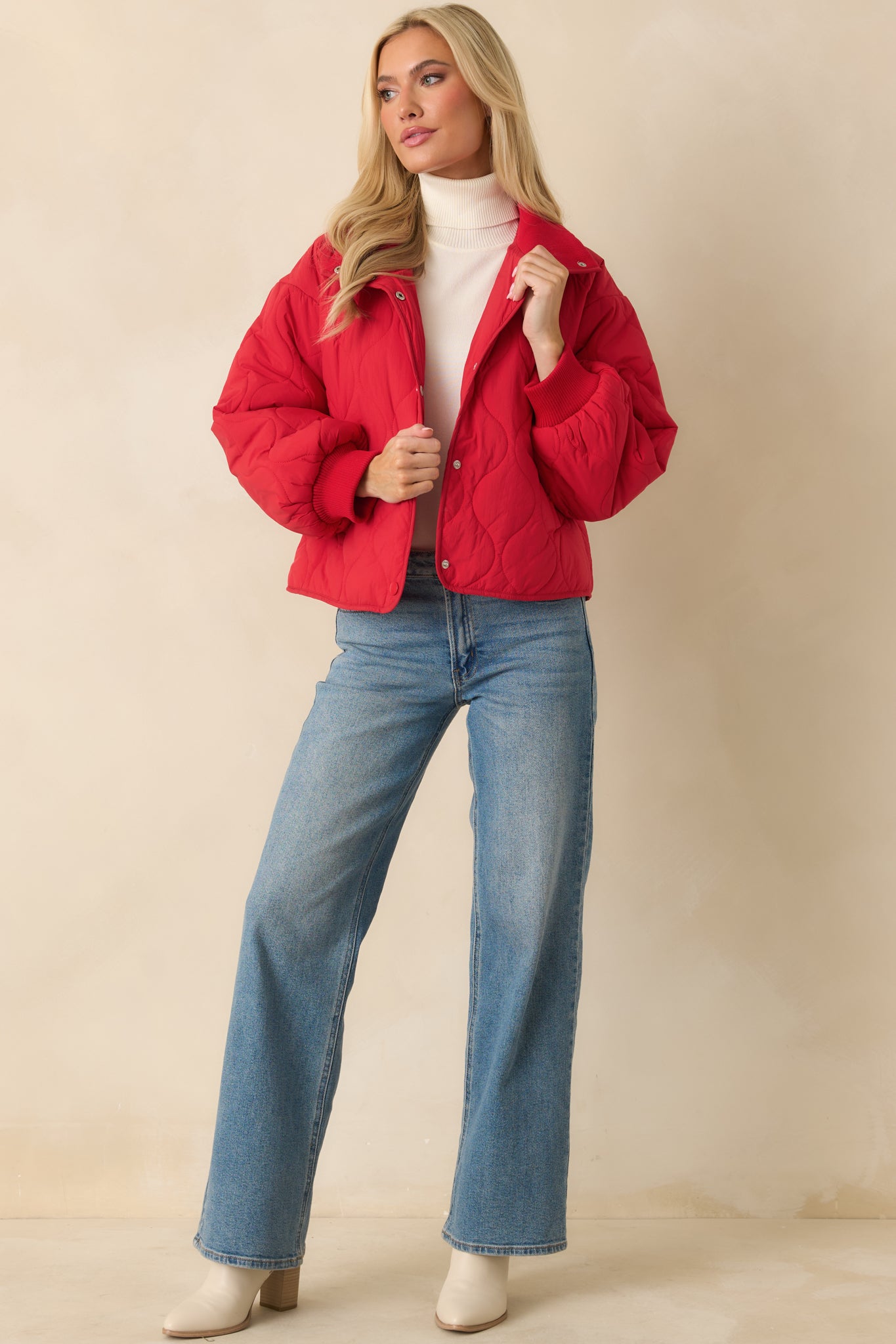 Full-body view of the red quilted jacket showing its relaxed fit and stand collar.