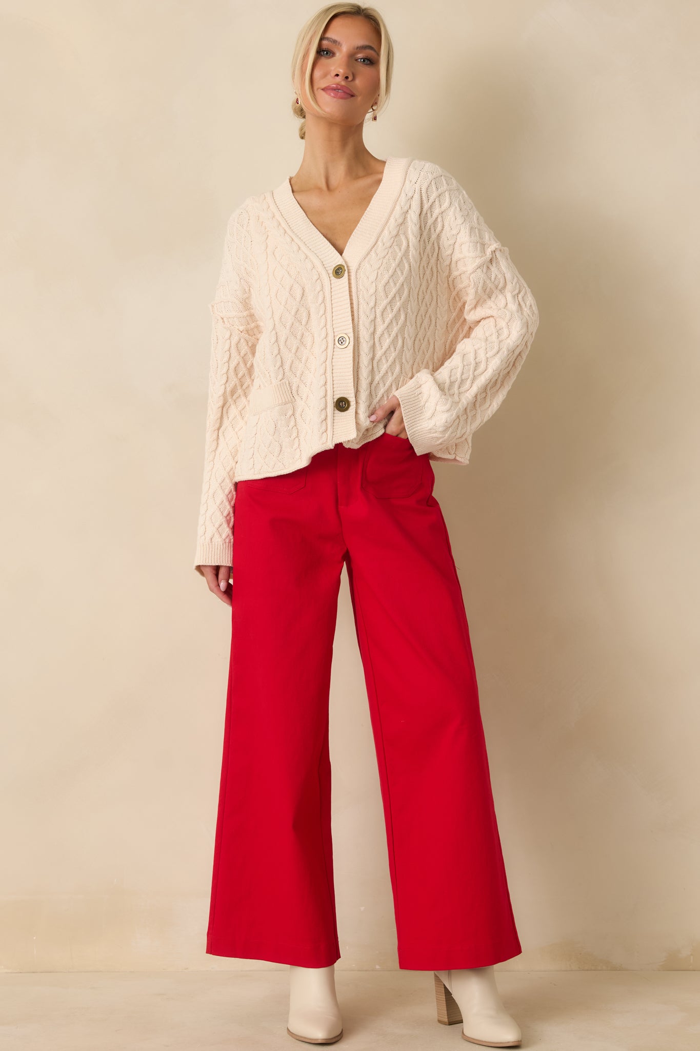 Full front angle of the ivory cardigan emphasizing the functional buttons and faux front patch pockets.