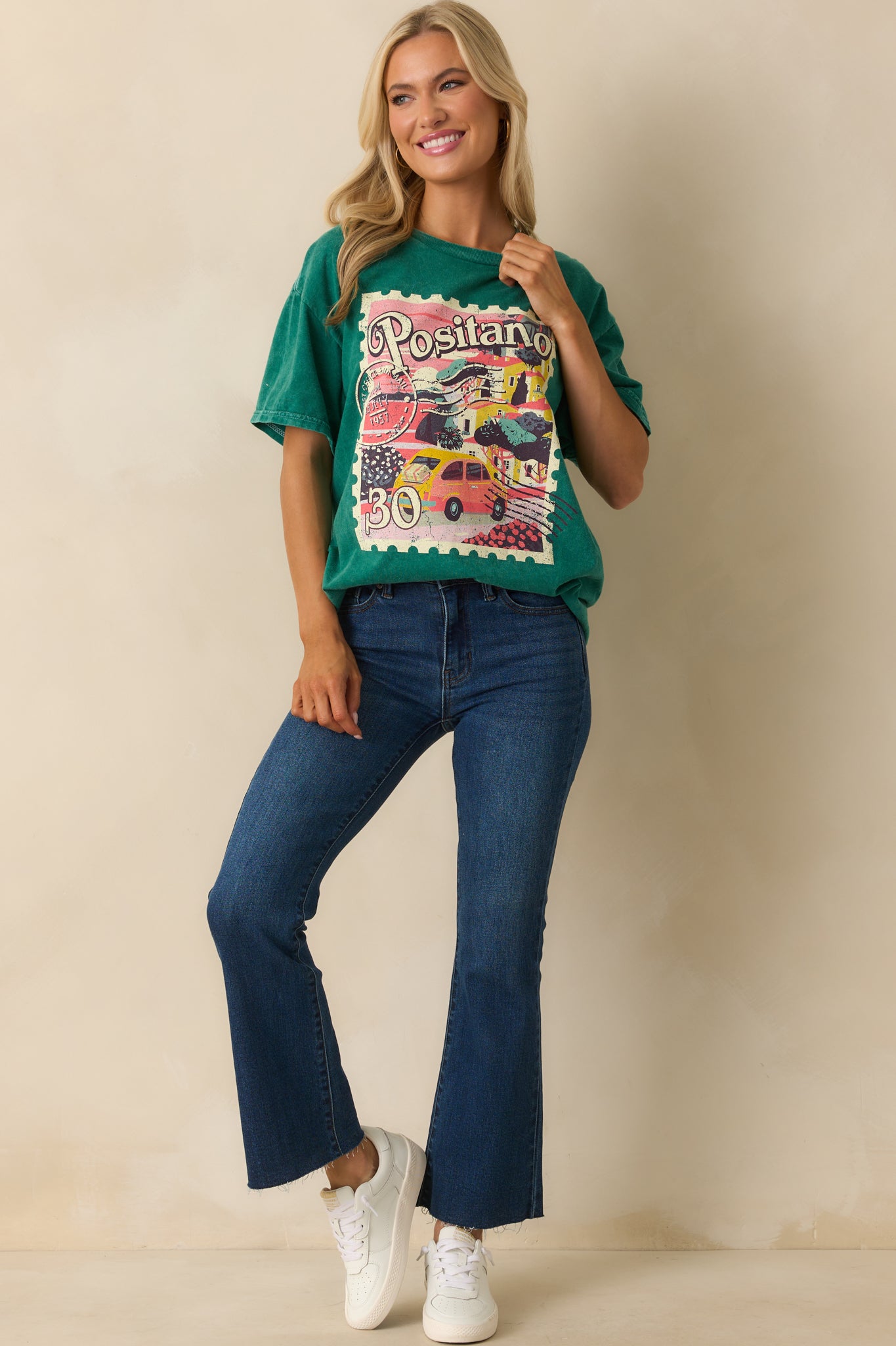 A full front view of the green acid wash tee with a Positano postage stamp graphic on the chest.