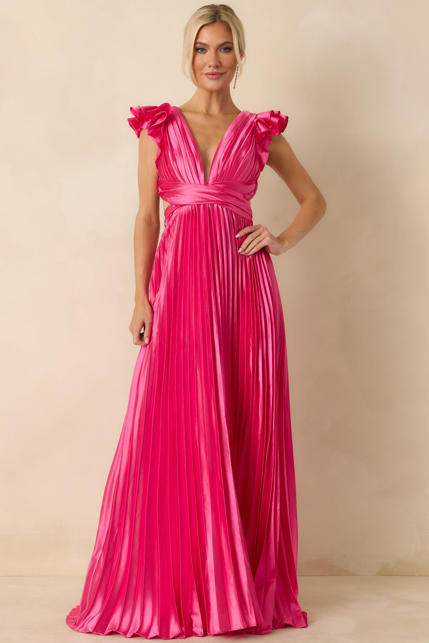 Full-length image highlighting elasticized back waistband, flowing pleated skirt, and side cutouts of hot pink dress.
