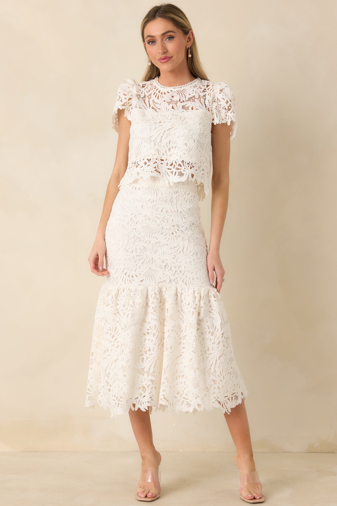Front-facing full body image highlighting the high waist and flared ruffle panel of the ivory lace skirt.